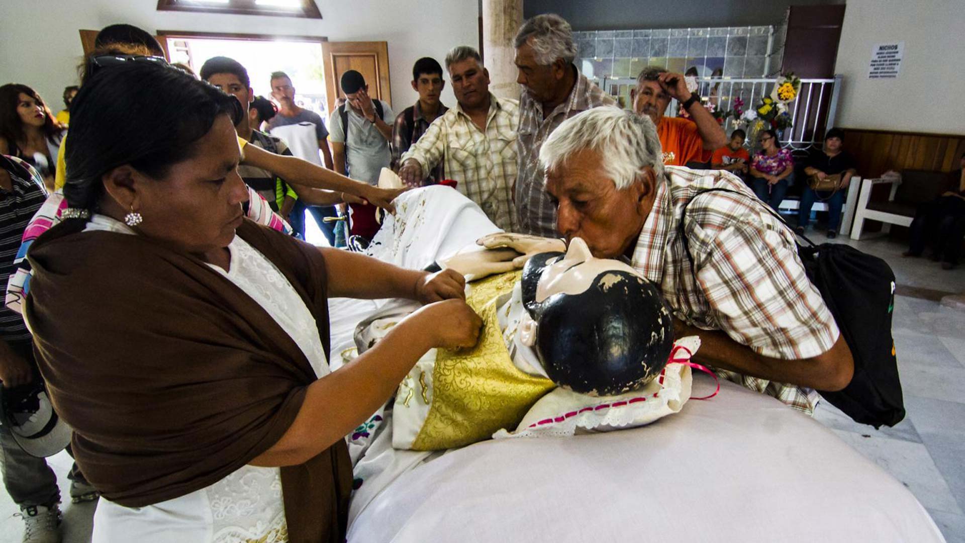 Pilgrims kiss a replica of the San Francisco Xavier in Magdalena, Sonora.