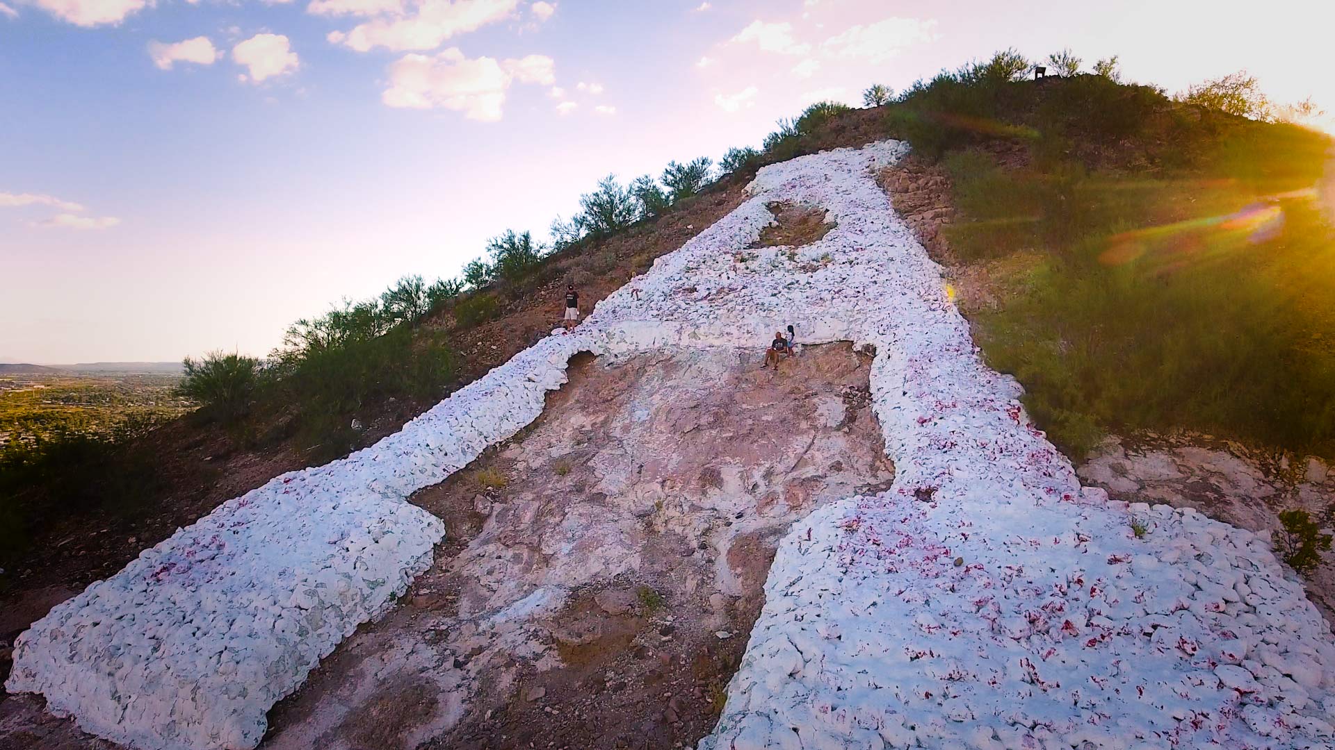 Visitors sit near the "A" painted on Sentinel Peak.