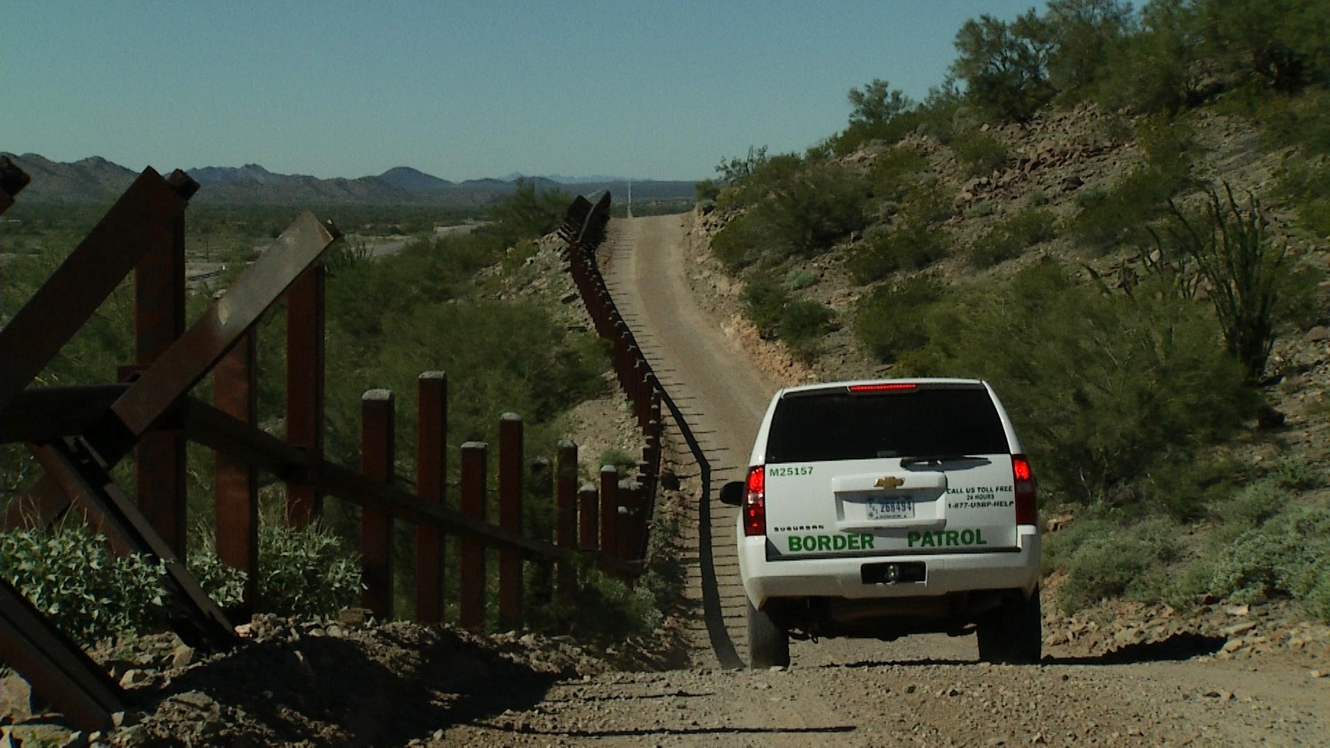 A Border Patrol vehicle drives alongside a barrier fence at the Organ Pipe National Monument west of Lukeville, Arizona on Friday, Nov 2, 2018. 