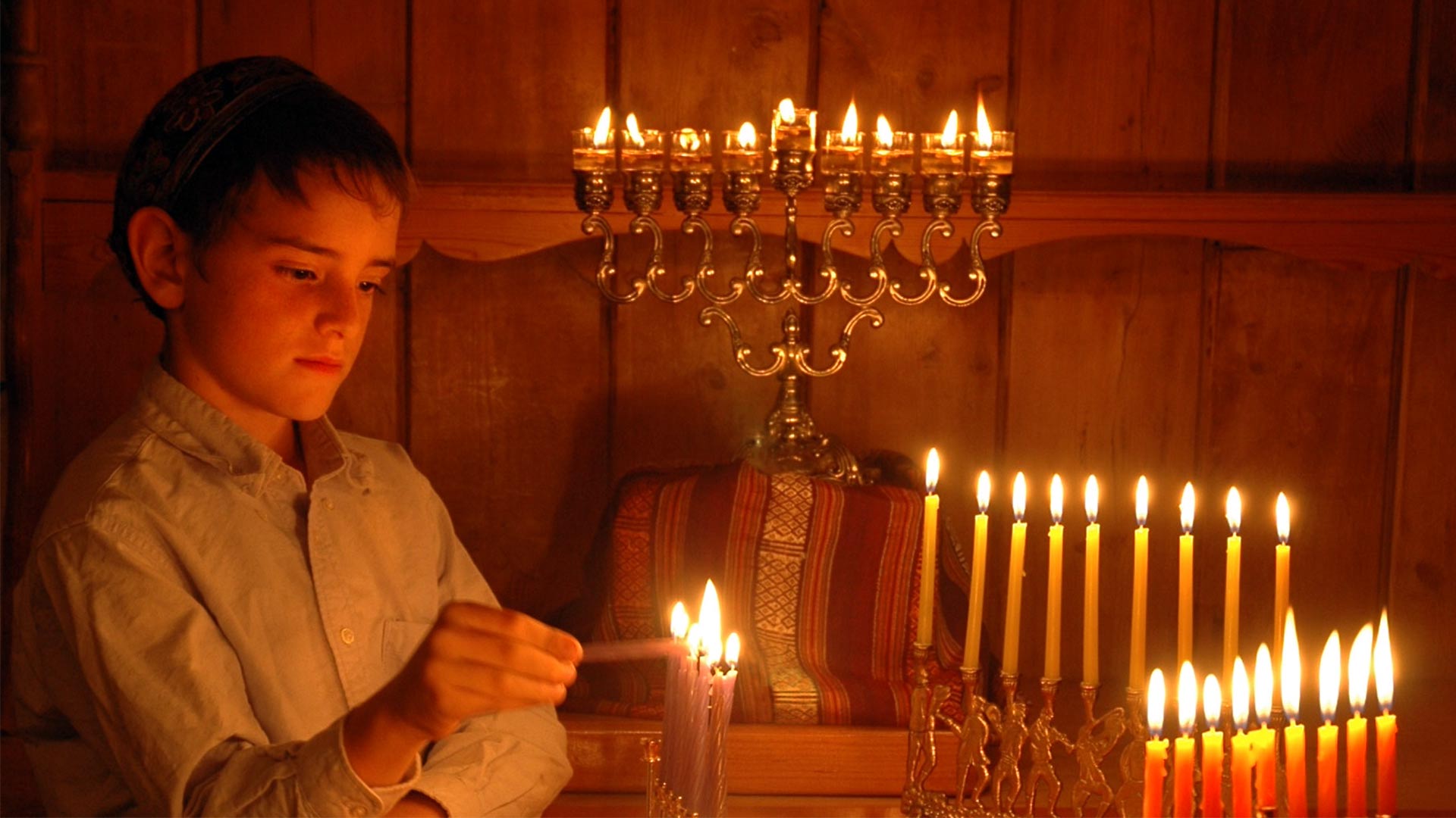 HANUKKAH: A FESTIVAL OF DELIGHTS examines the traditions at the center of the Jewish holiday of Hanukkah, including lighting candles for eight nights on the lamp known as a menorah.