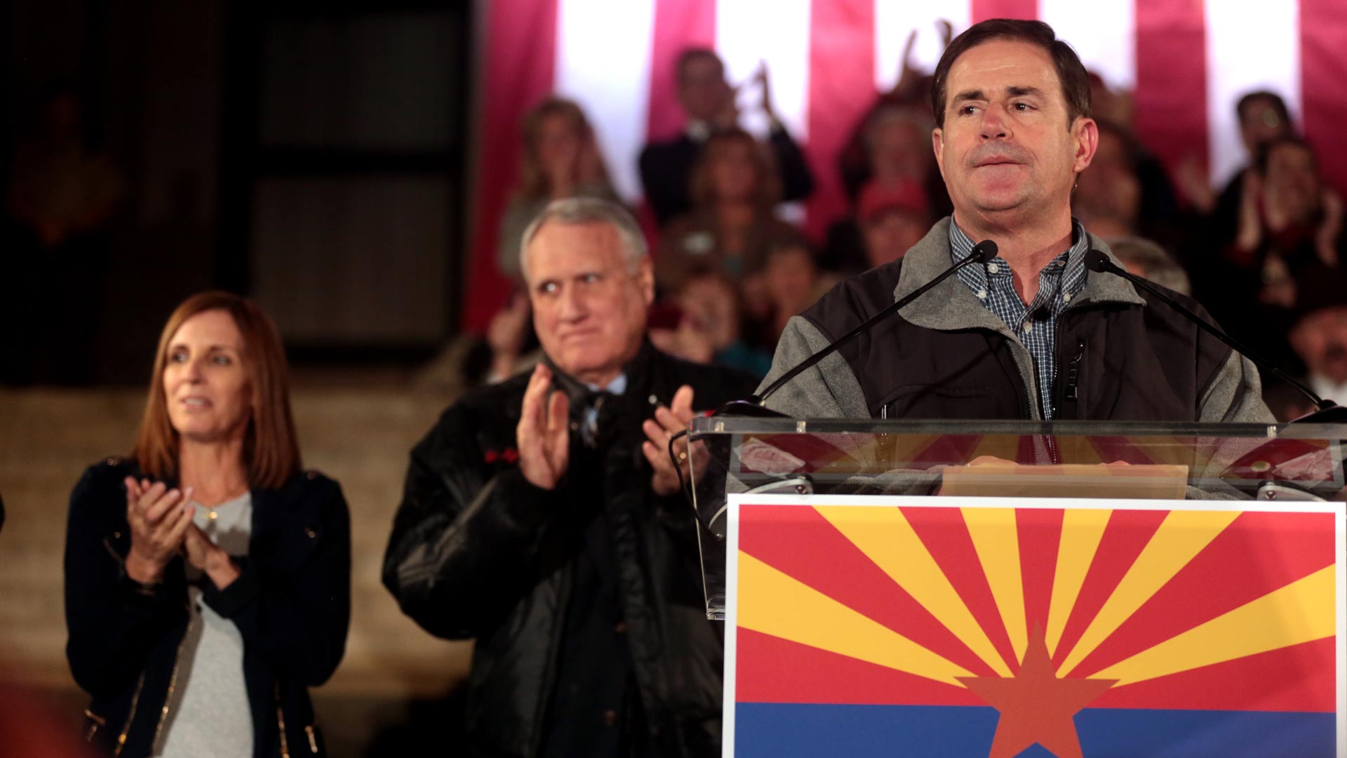 Gov. Doug Ducey speaks at an event on the eve of the election, 2018. Behind him are Martha McSally and Jon Kyl.