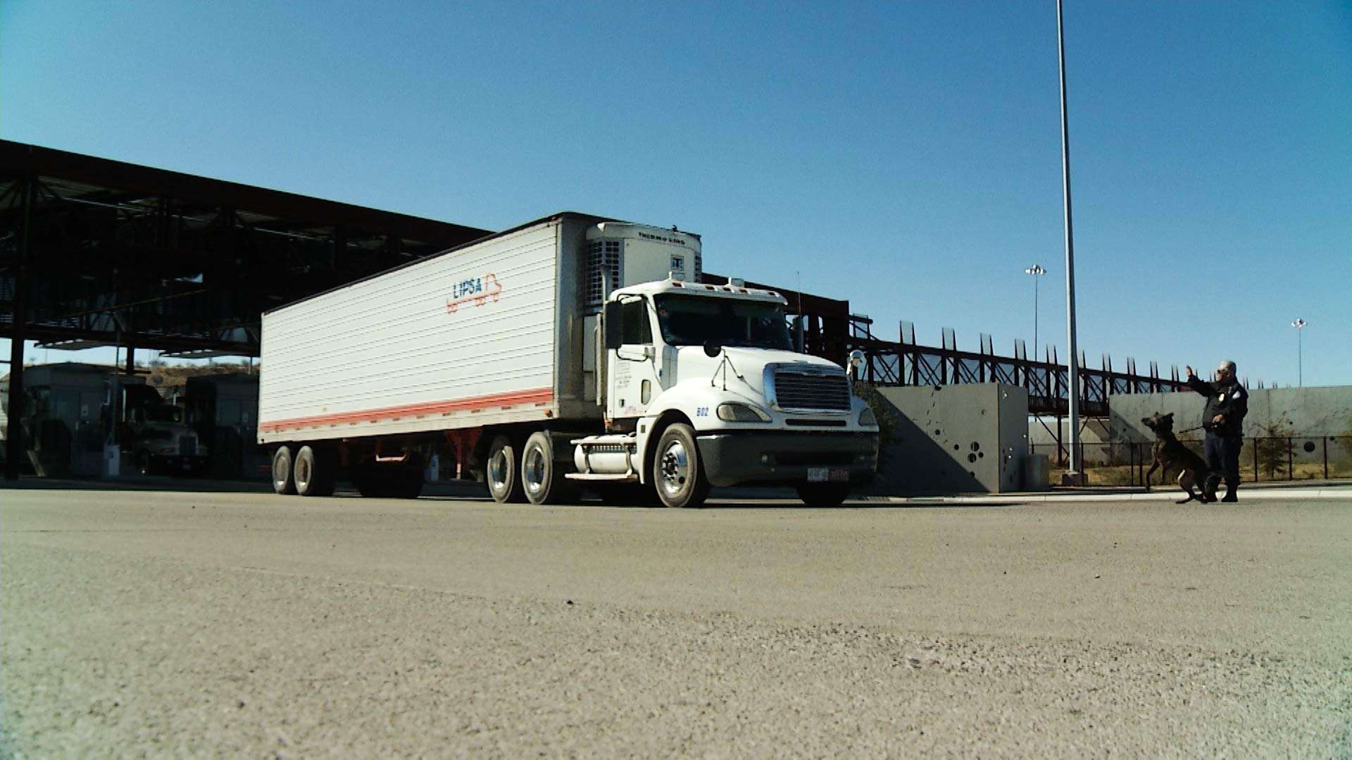 A dog inspects a truck crossing the U.S.-Mexico border at the Mariposa Port of Entry.