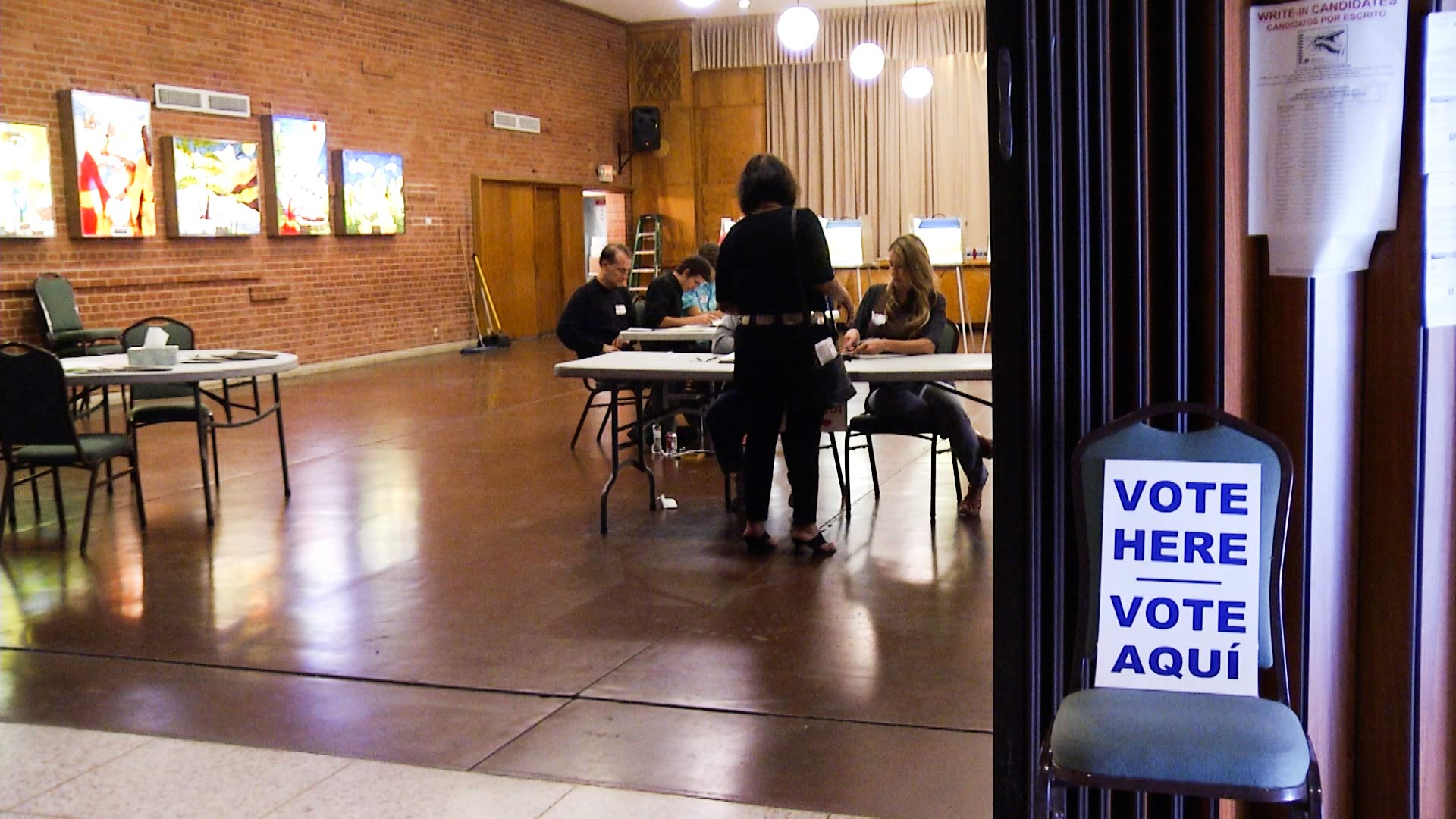 Volunteers check voter registration at a voting station.