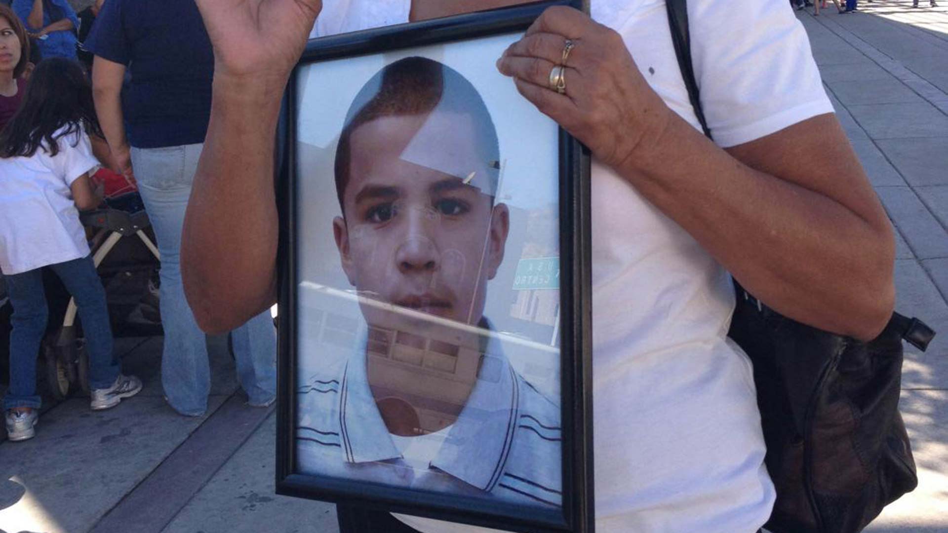 Taide Elena carries a portrait of her grandson, Jose Antonio Elena Rodriguez, who was shot and killed in October 2012.