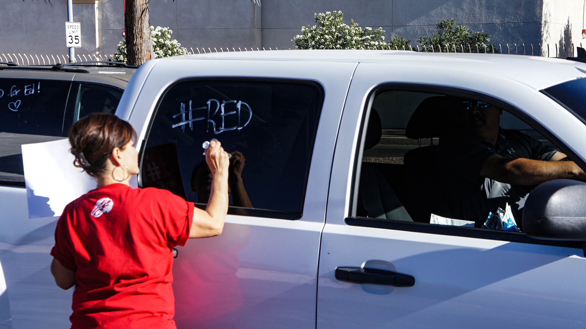 A demonstrator on Tucson's west side writes #RedForEd on the car windows of drivers sympathetic to the movement for education funding, April 24.