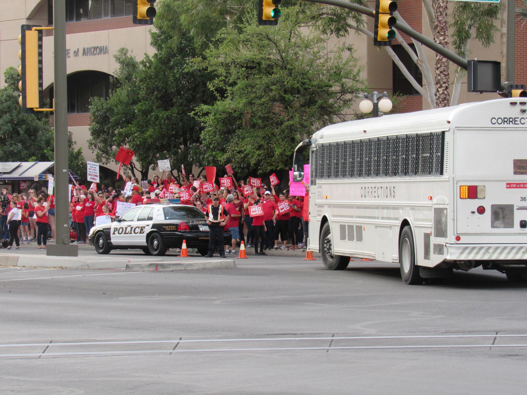 Corrections bus drives past rally 