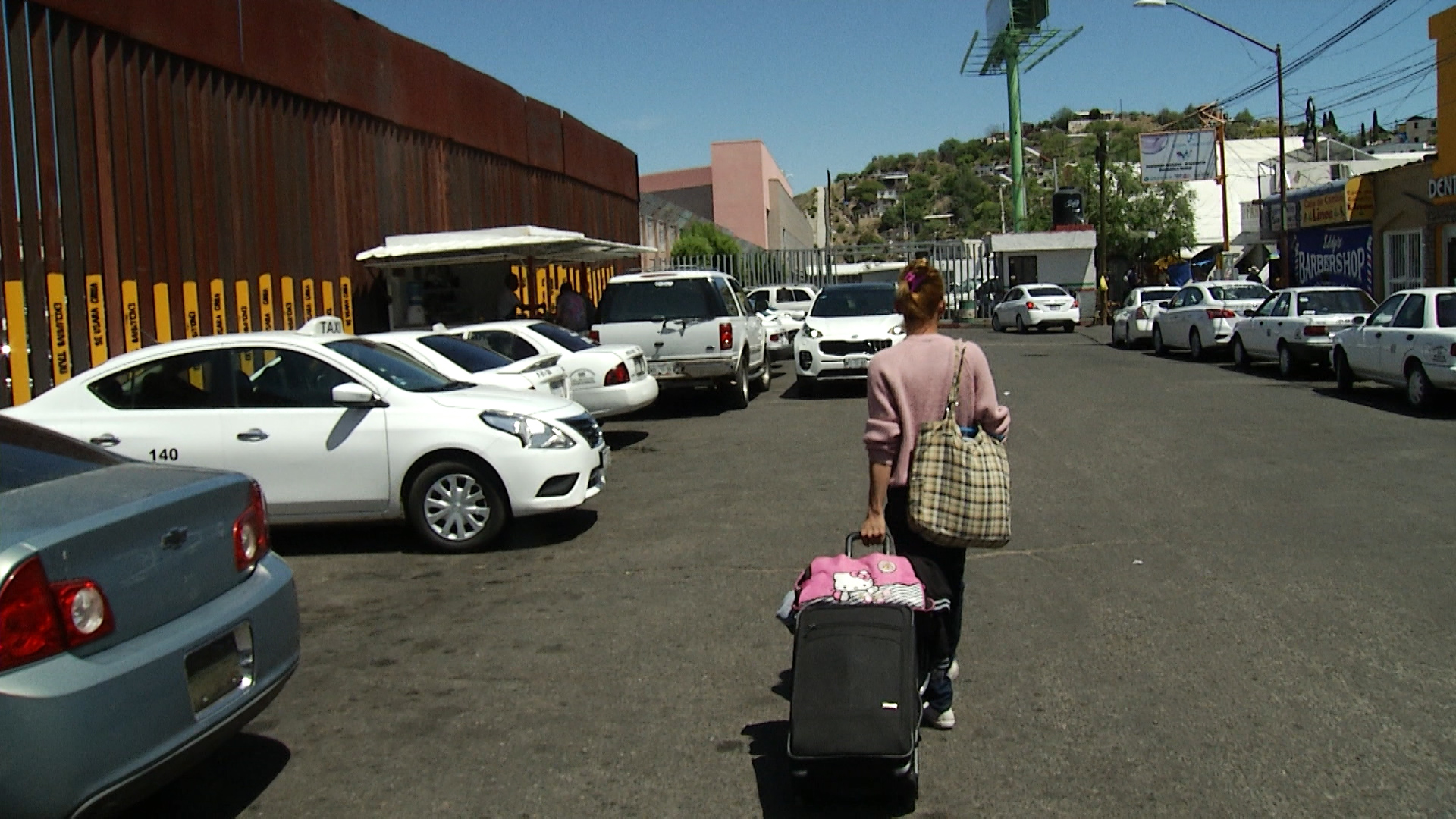 Nicol carries her luggage to the port of entry in Nogales to seek asylum.