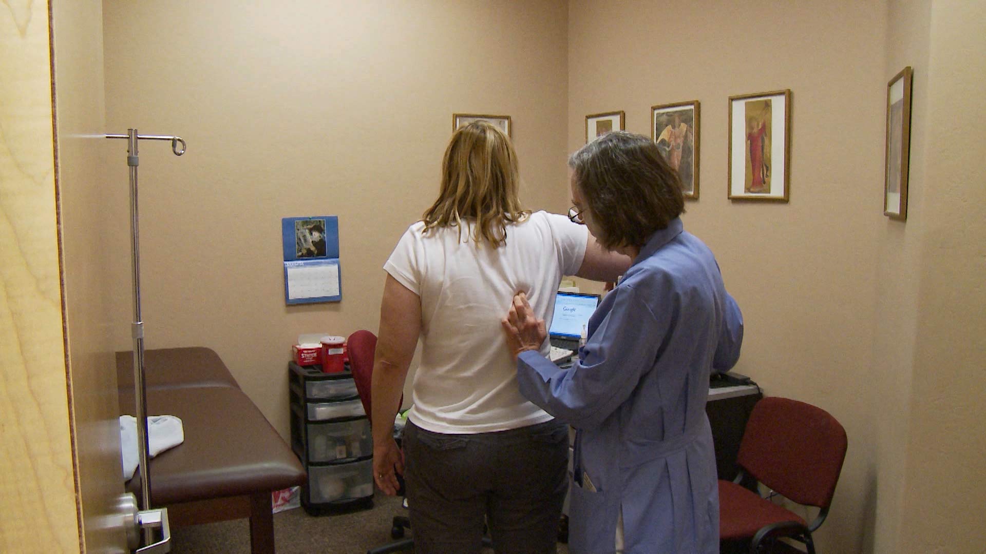 A health professional examines a patient.
