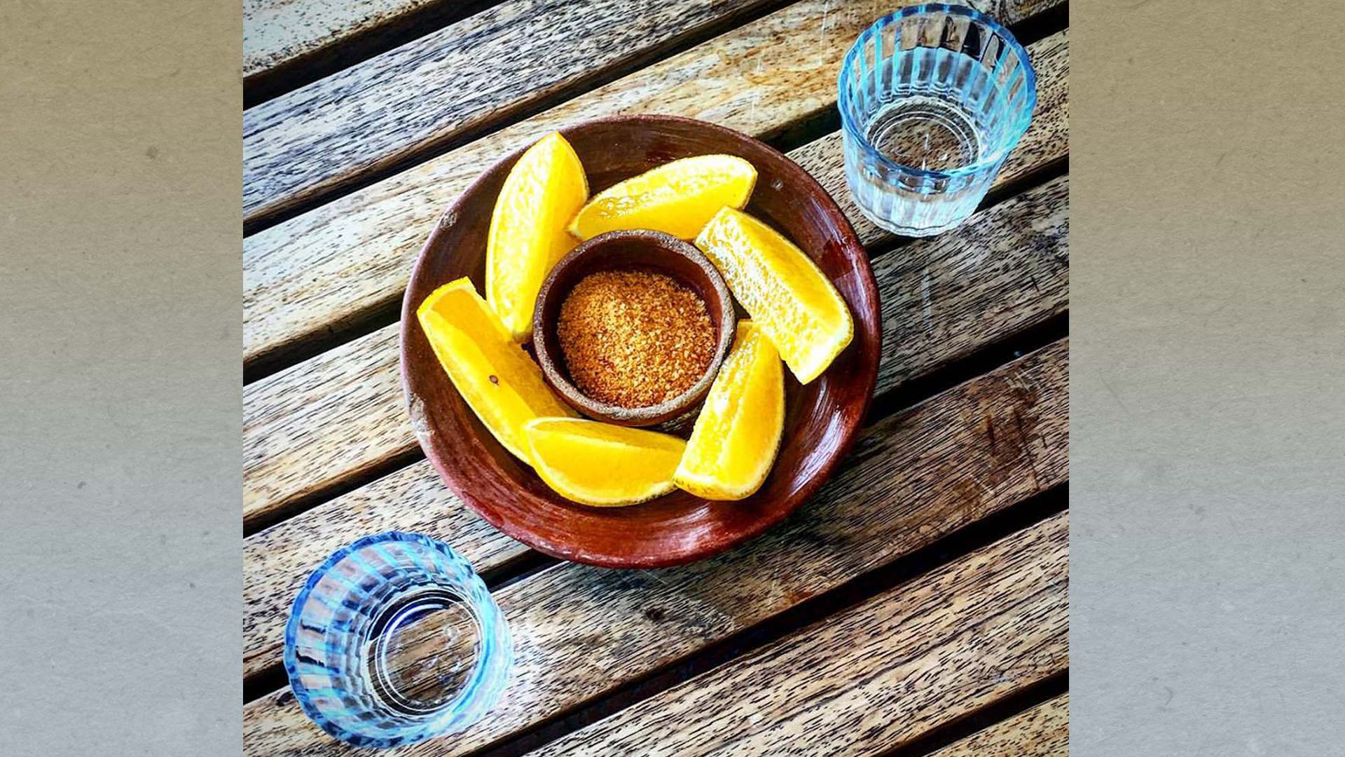 Mezcal is traditionally served in shot glasses with orange slices covered in chilli powder or "sal de gusano."
