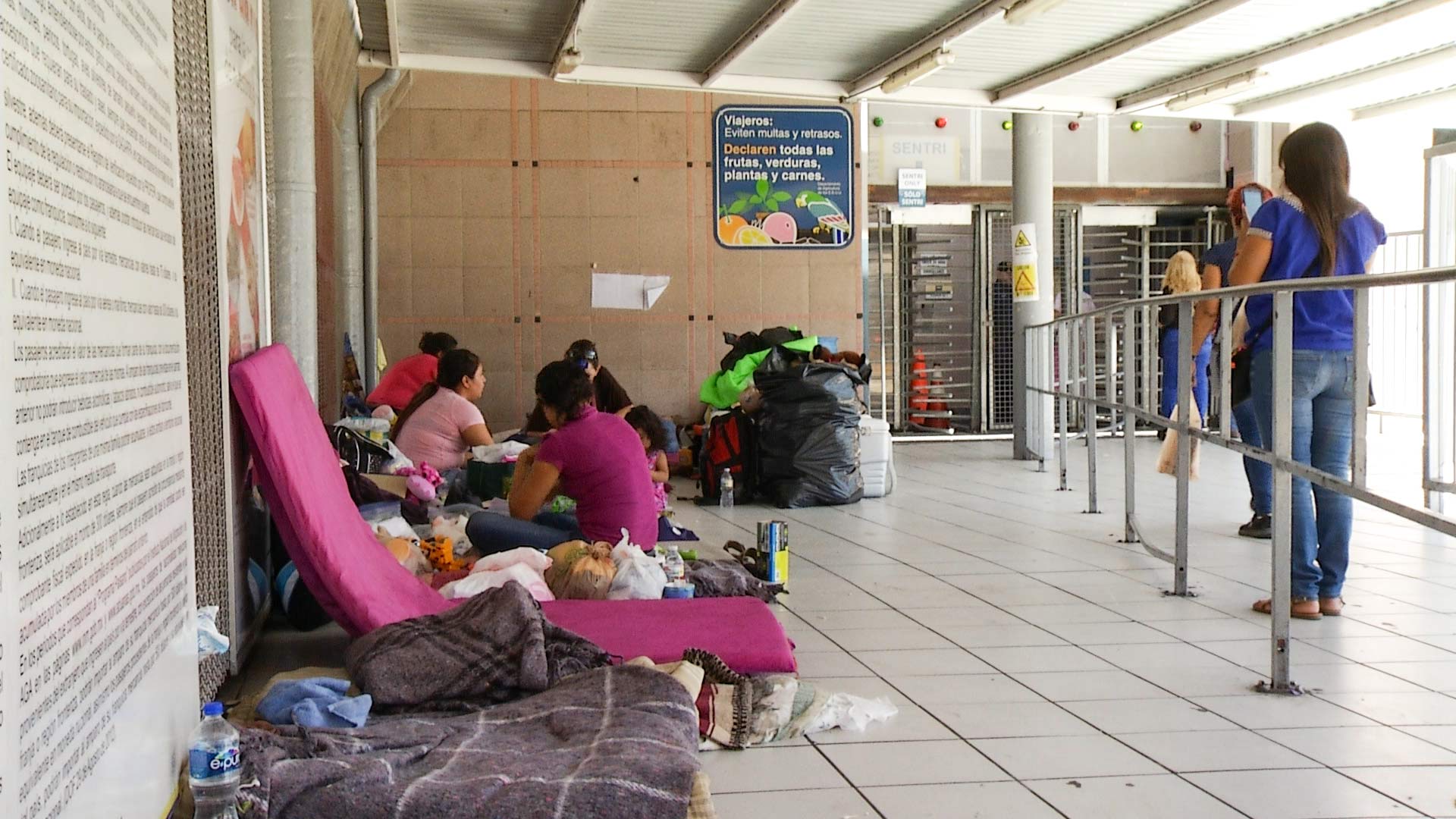 At left, family members wait for their chance to submit asylum claims in Nogales, Mexico, June 7, 2018. At right, pedestrians approach a turnstile to enter the U.S. on foot.