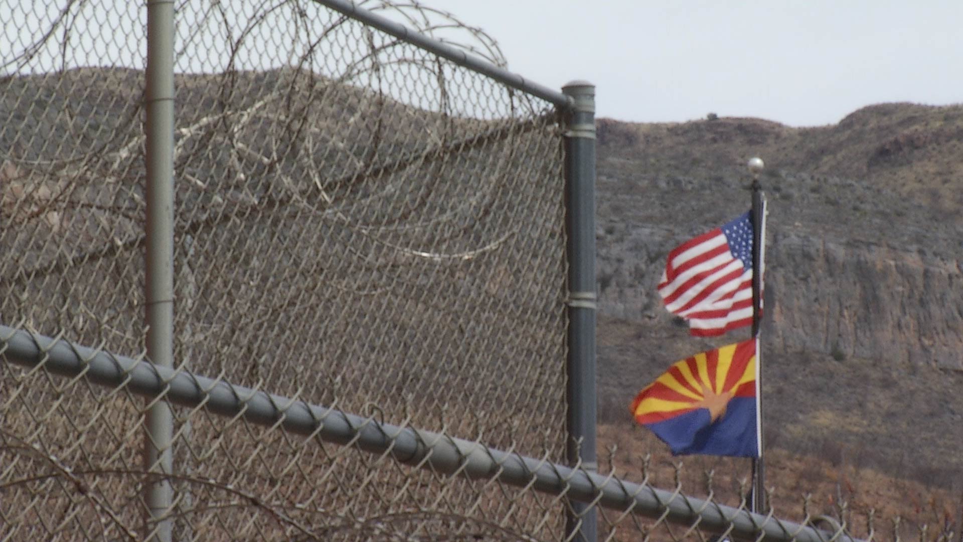 Flags for Arizona and the United States wave in the wind outside the Cochise County Jail.