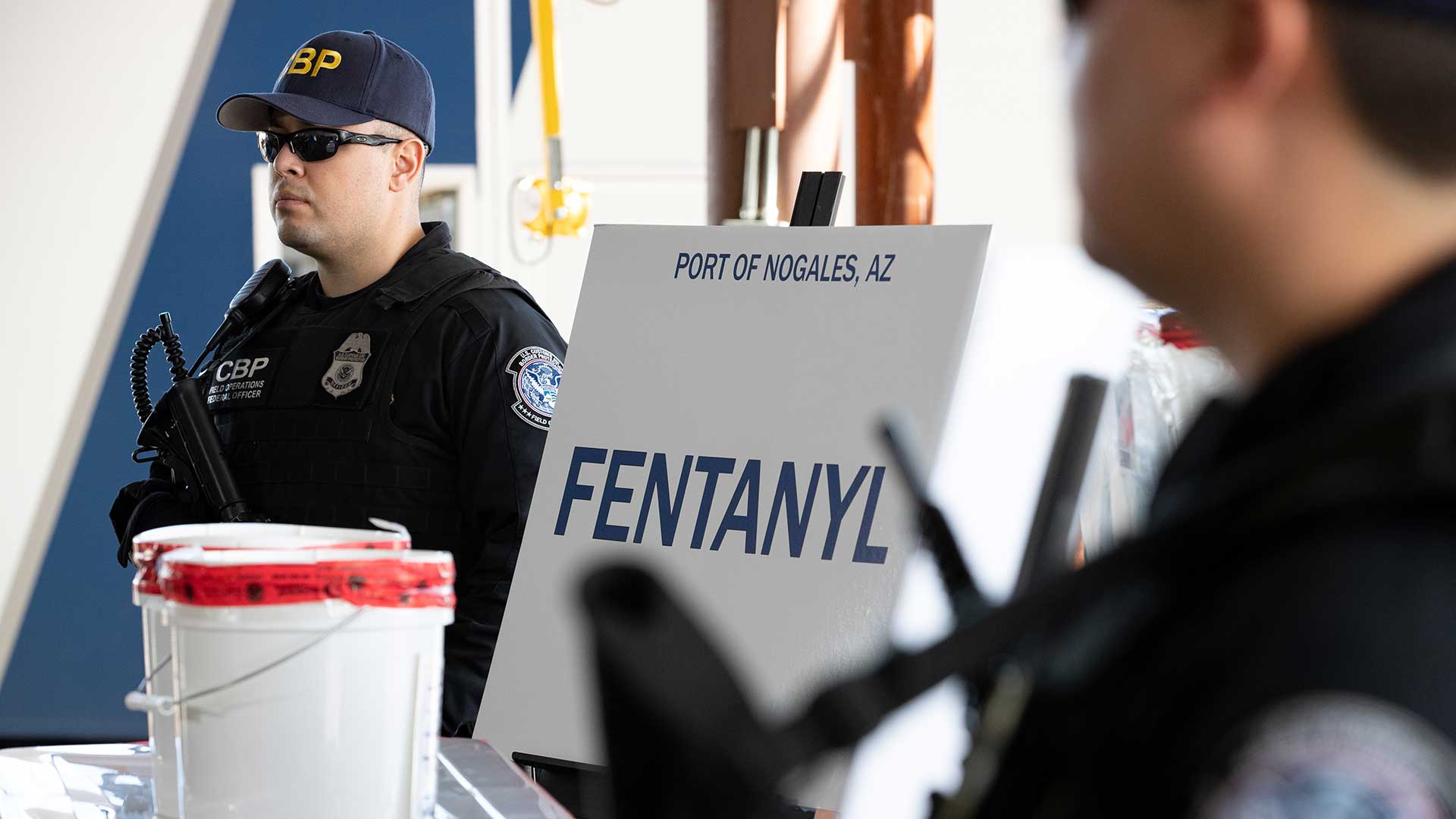 CBP officers stand guard next to fentanyl seized by the agency at the Port of Nogales Jan. 26, 2019.