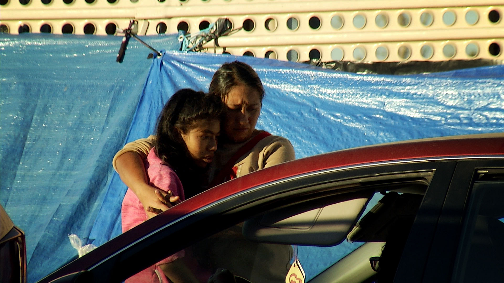 A woman and child embrace along the border in San Luis Río Colorado, Sonora where migrants seeking asylum formed an encampment along the sidewalk as they waited to make formal requests with U.S. Customs officers at the San Luis Port of Entry in December 2018. 