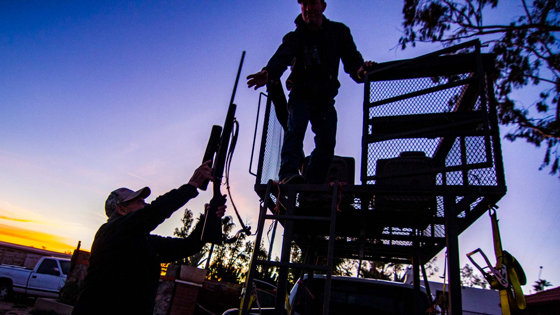 Outfitter Jim Schaafsma hands a rifle to hunter Brandon Barnwell.