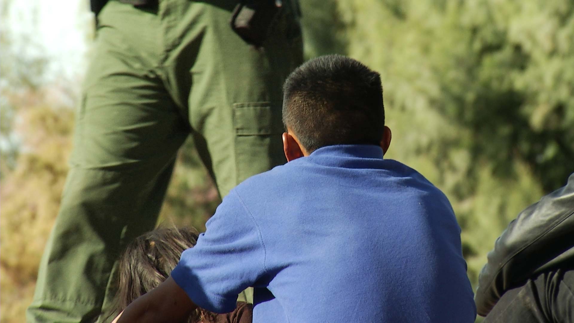 A child and a man await processing by border agents as part of a group seeking asylum in the Yuma Sector, December 2018.