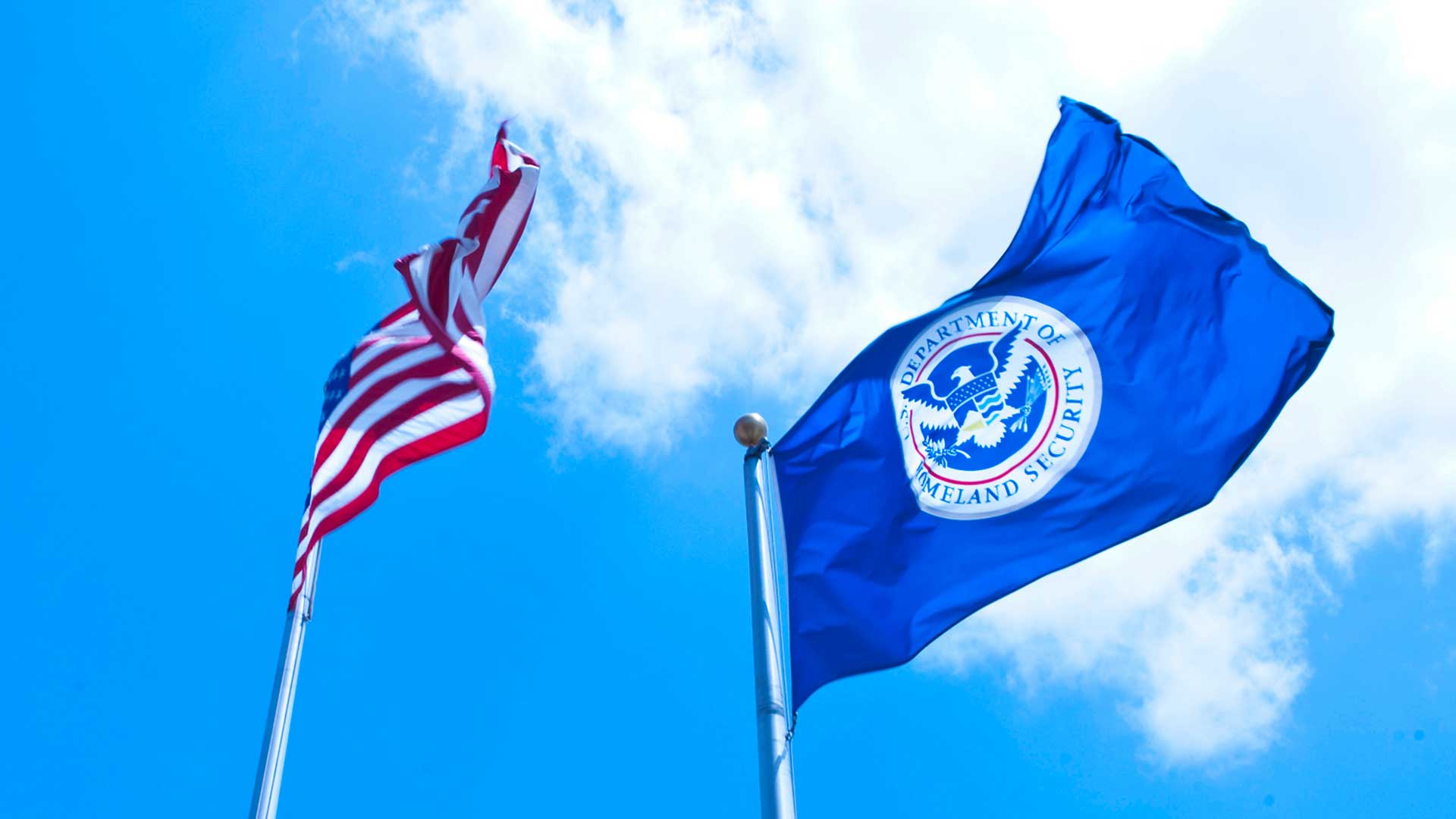 The American flag and a flag bearing the seal of the Department of Homeland Security.