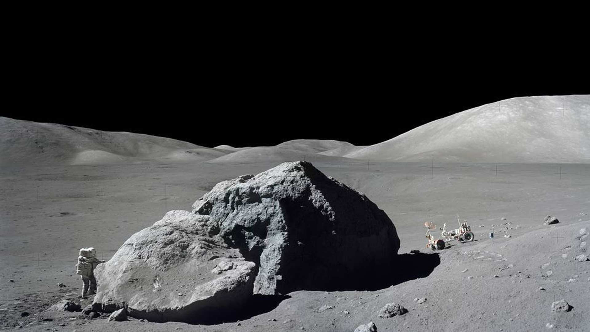 Harrison H. Schmitt stands next to a split lunar boulder on the Apollo 17 mission in this photo from Dec. 13, 1972.