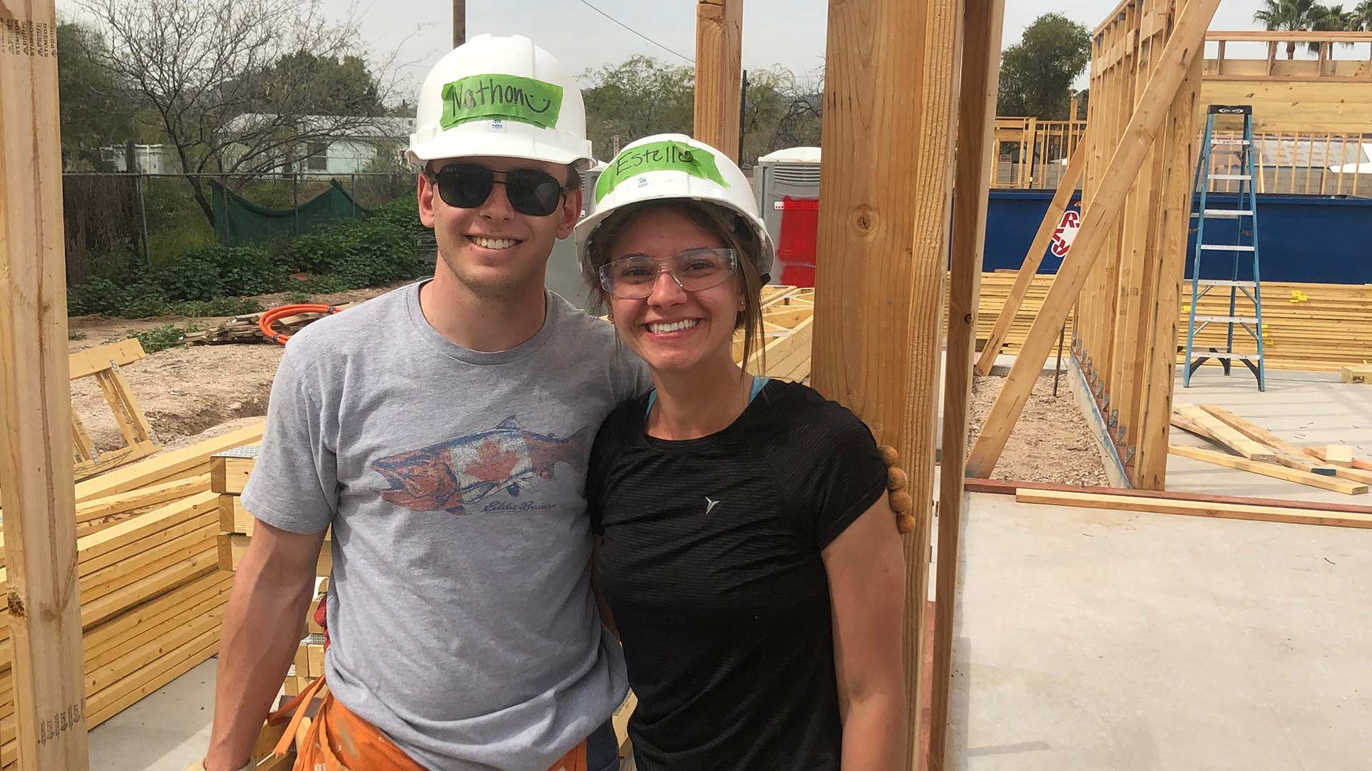 University of Arizona students Nathon Smith and Estelle Brugere in front of a wall they constructed at a Habitat for Humanity site in Tucson over spring break