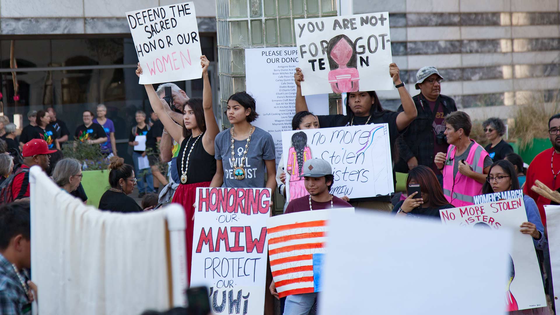 Demonstrators at the 2019 Tucson Women's March carry signs reading "MMIW" ("missing and murdered Indigenous women") and "no more stolen sisters."