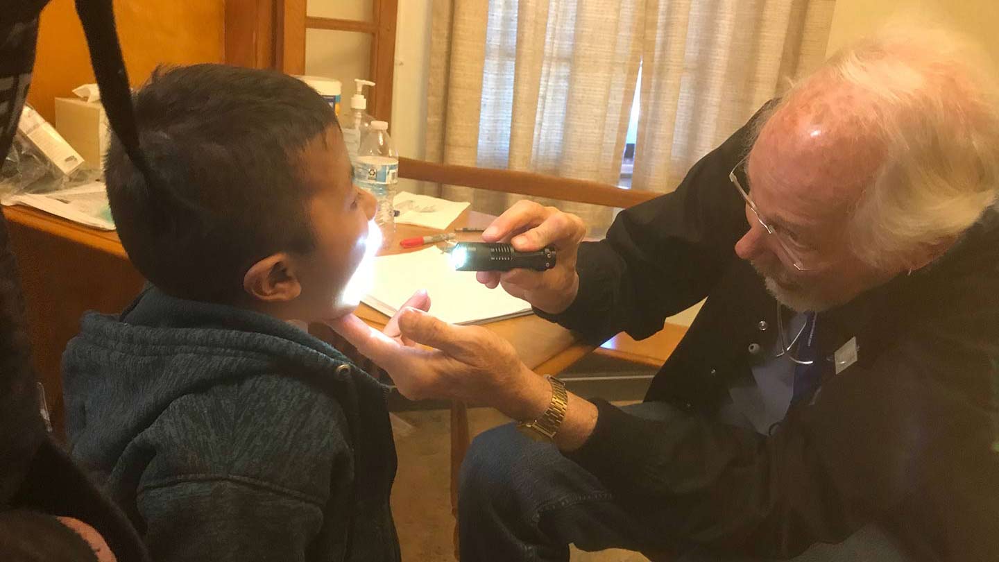 A volunteer pediatrician examines a 7-year-old from Guatemala at the Tucson Benedictine Monastery, March 28, 2019.