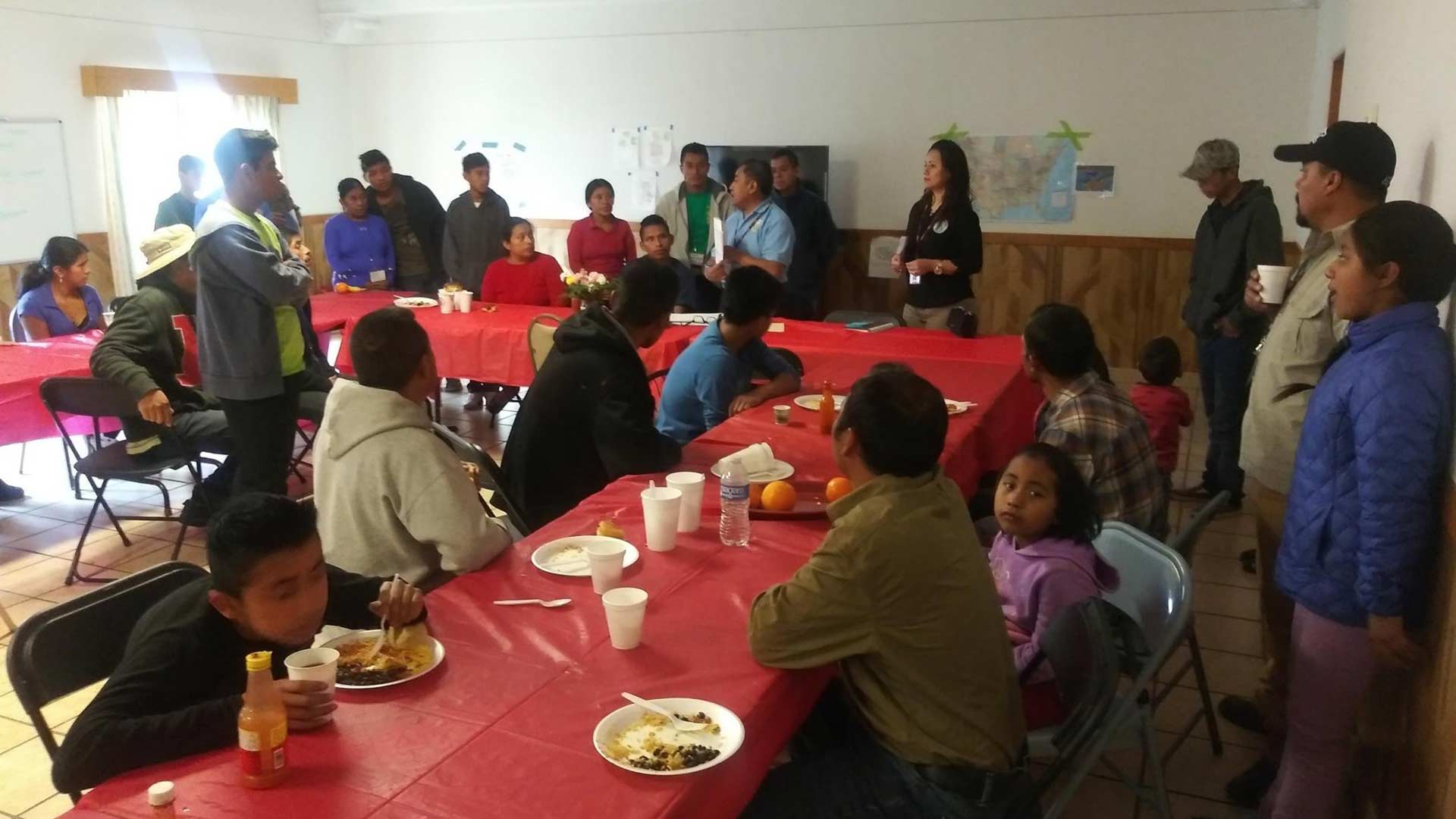 Sebastian Quinac from the Guatemalan Consulate in Tucson gives an orientation to Central American migrants arriving at the Tucson Benedictine Monastery. (In blue shirt at the center of the group holding a white pamphlet, March 16, 2019)