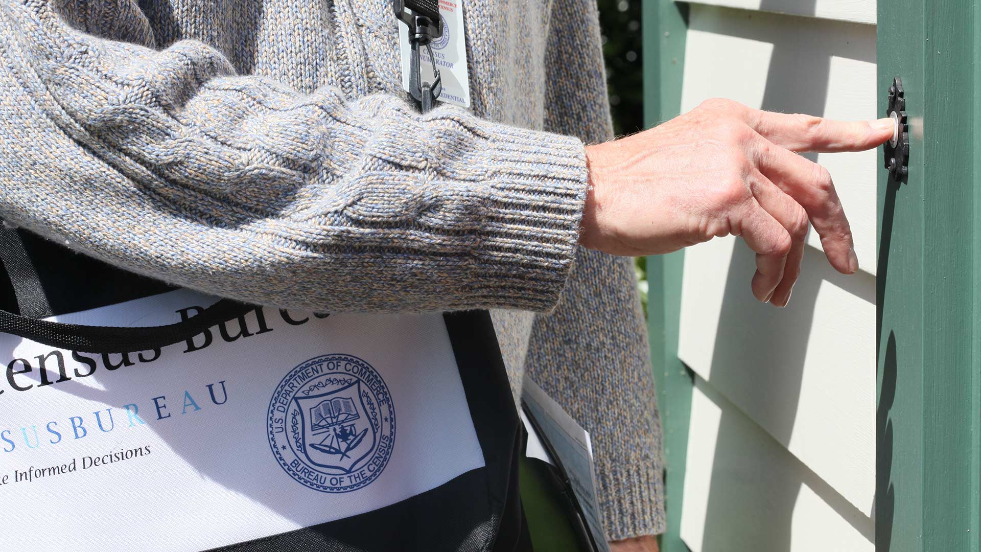 A census 2010 employee rings a doorbell.