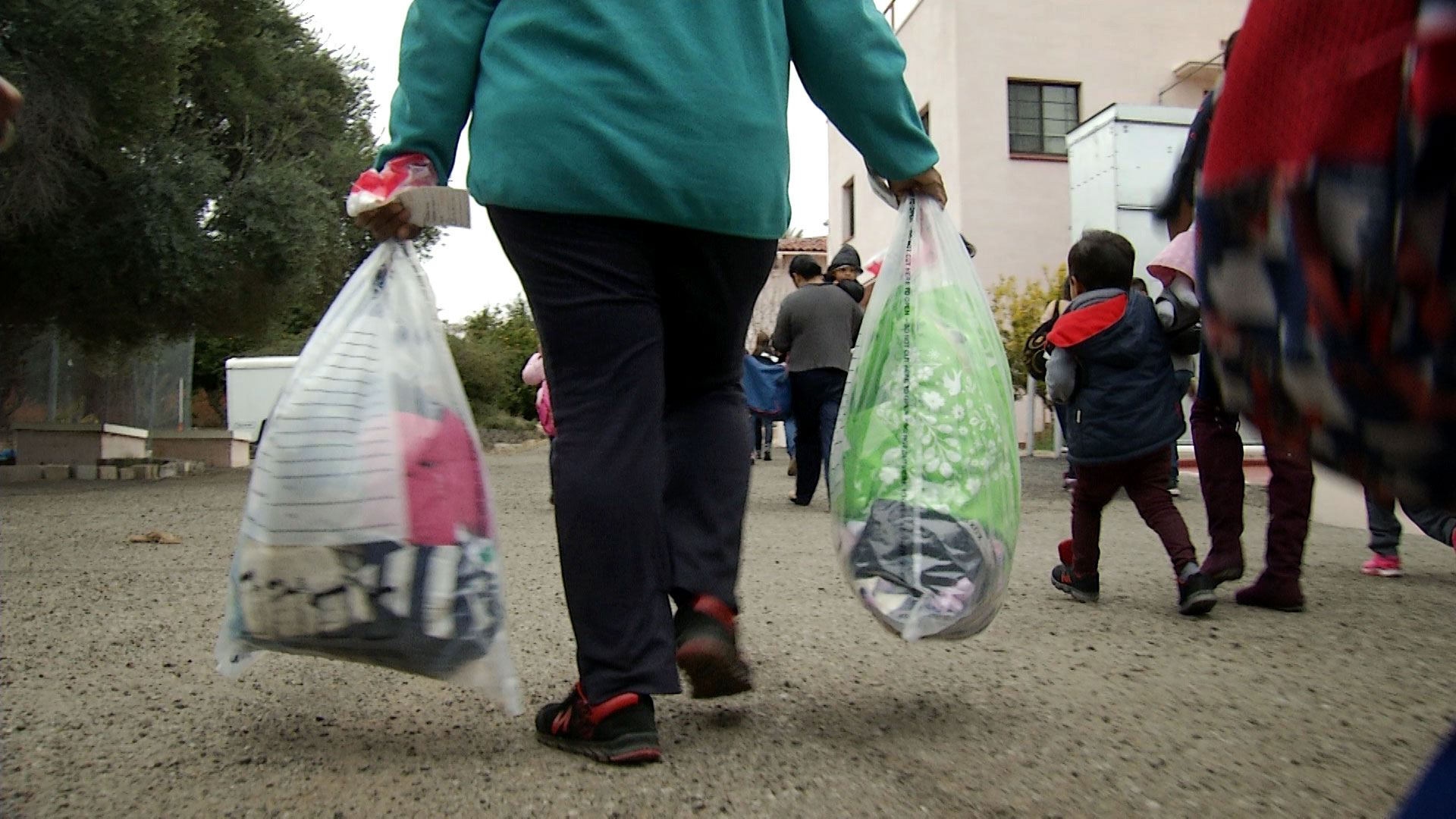 A woman carries her belongings into the Benedictine Monastery shortly after arriving as part of a group of migrants transported by the Department of Homeland Security from El Paso to Tucson on Feb. 21, 2019.