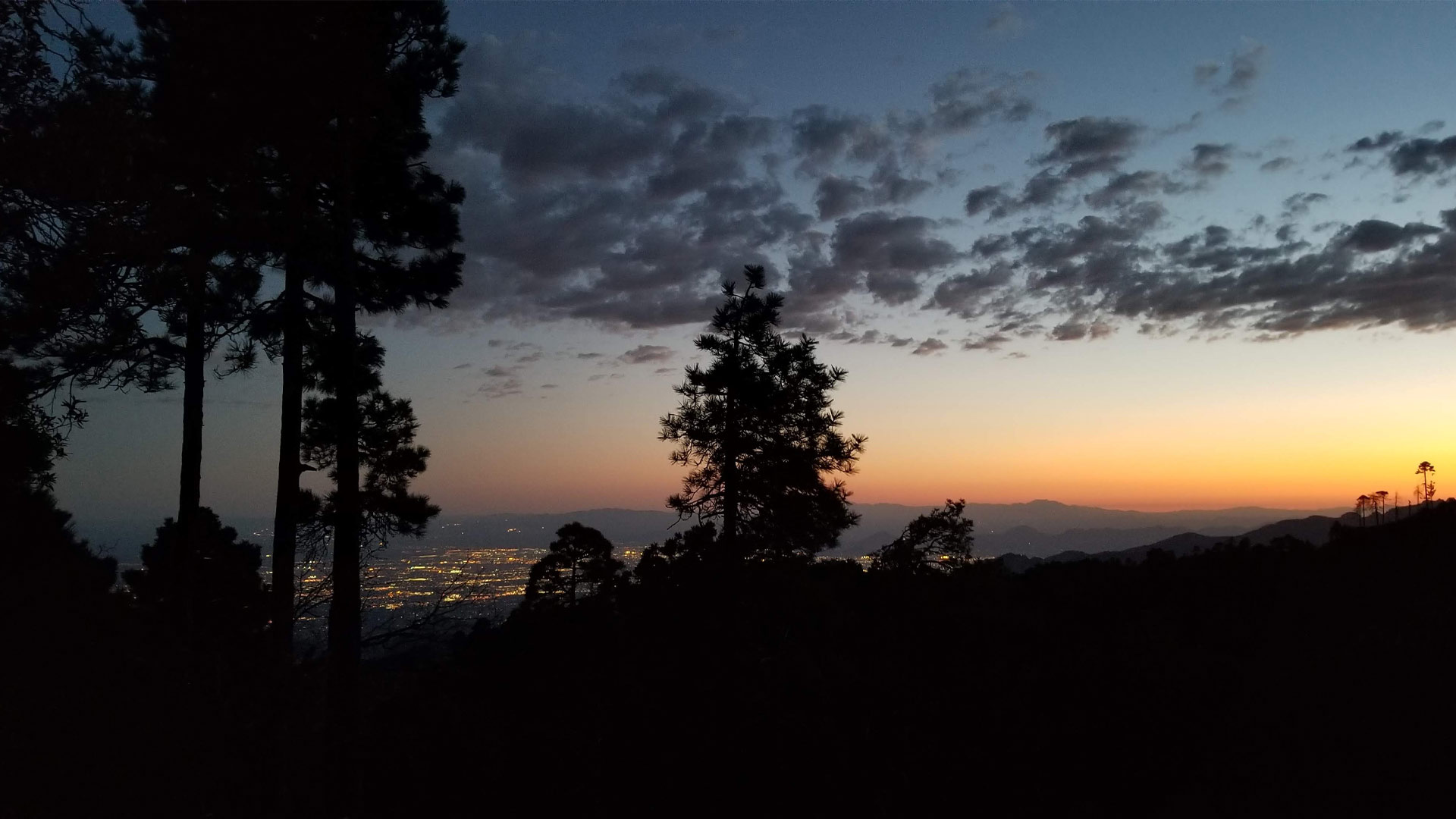 Tucson city lights are visible at sunset from the Catalina Mountains.