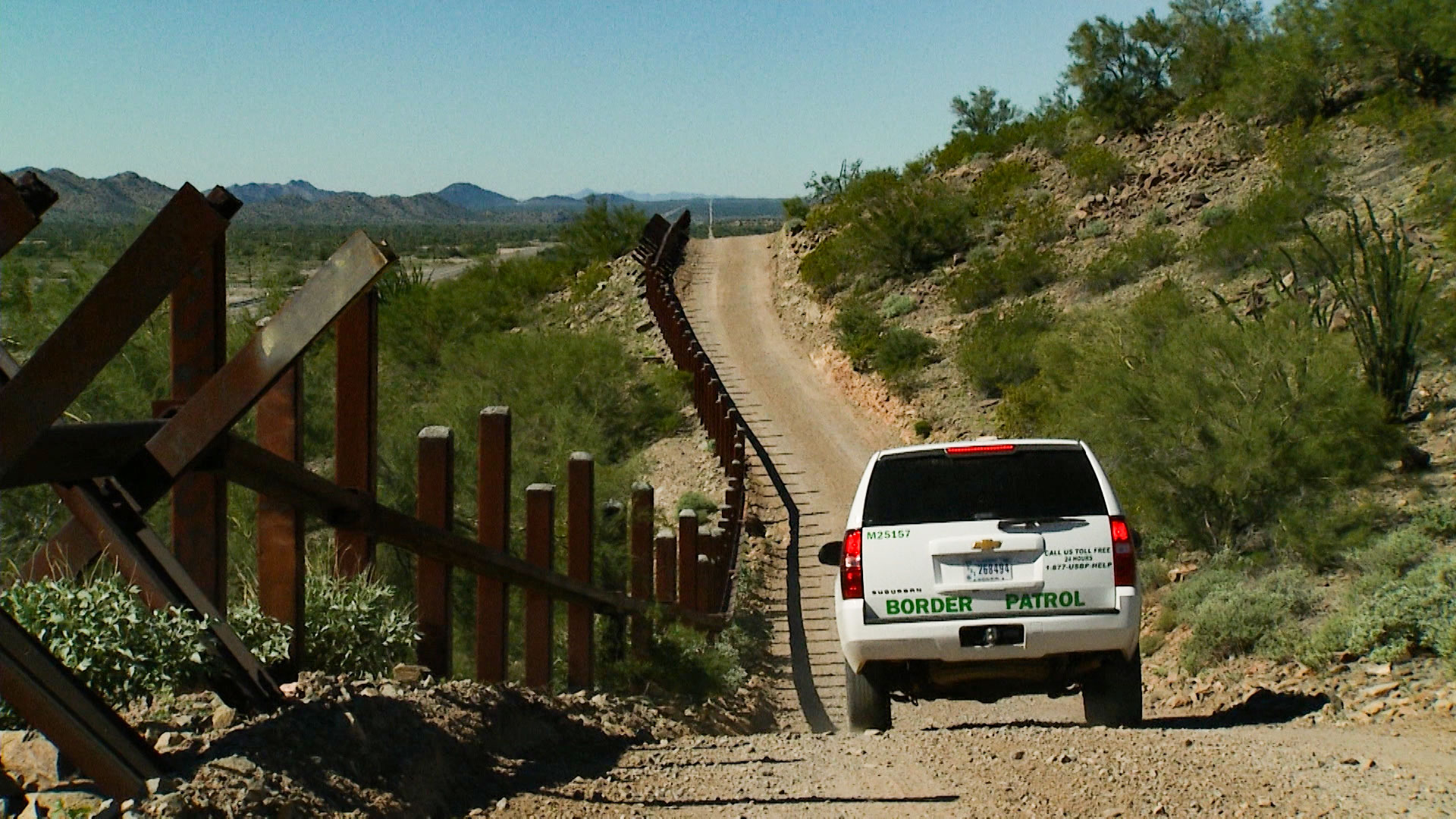 A Border Patrol vehicle drives along a section of fence at the Organ Pipe National Monument, west of Lukeville, Arizona, on Friday, Nov. 2, 2018. 