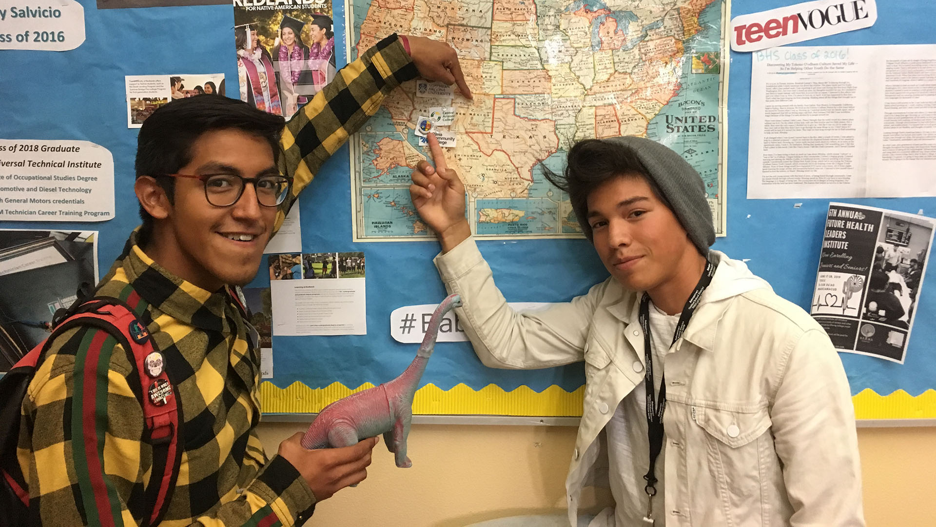 Jonah Patricio, left, and Daniel Marquez, right, pose with their class mascot, Dennis, as they point to colleges they'll be attending in the fall of 2019. 