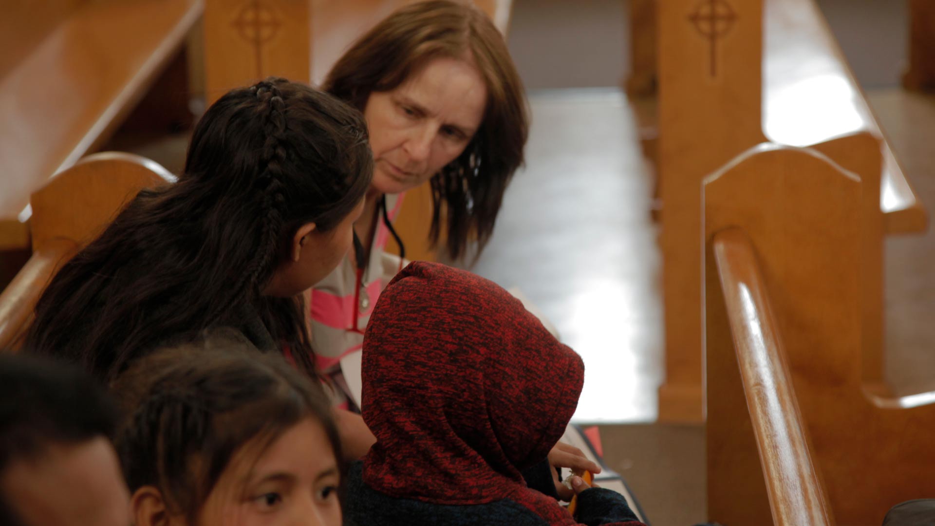 A volunteer at Tucson's Benedictine Monastery reviews when and where an asylum seeking family must appear for an immigration hearing, May 2019. 