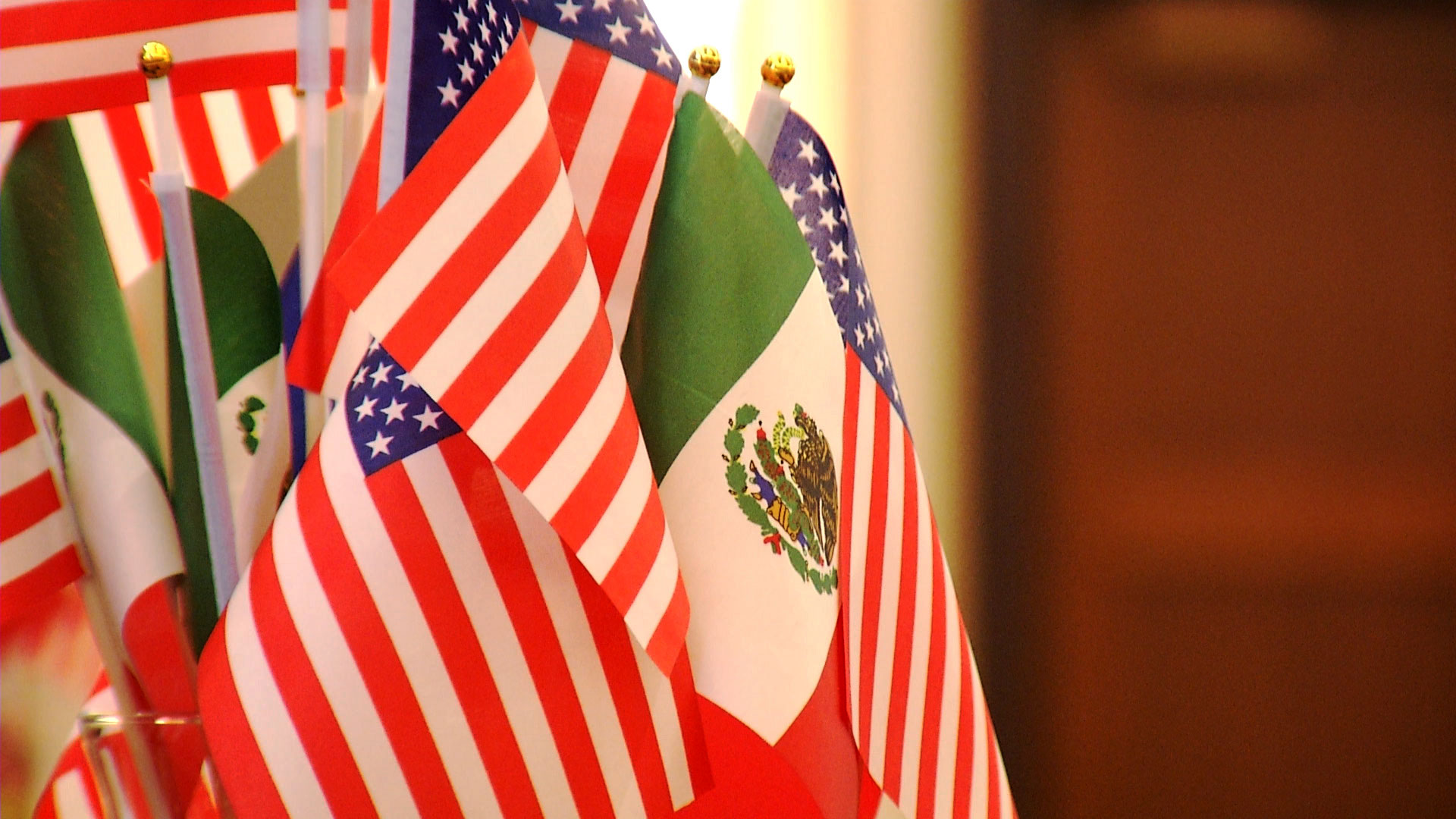 Flags representing the United States and Mexico are bundled together decoratively. 