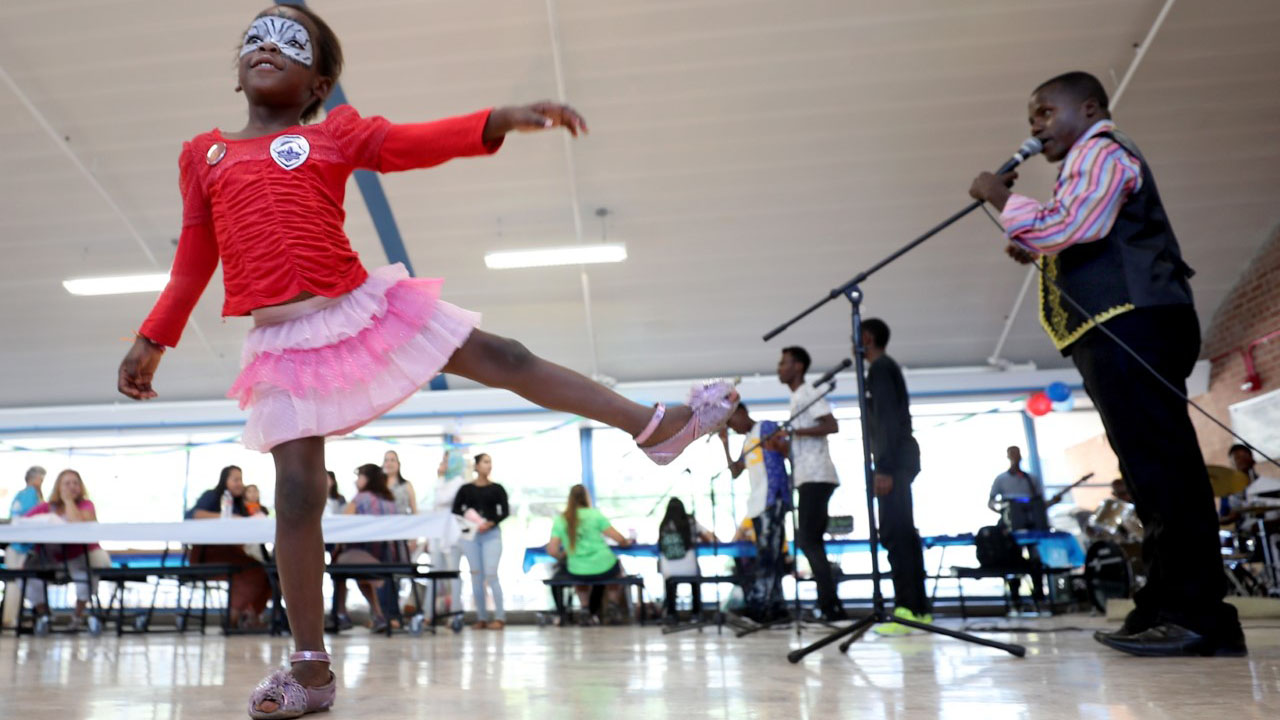 Madeleine Erasto, who's family are refugees from the Congo, dances to the live music at the family fun fest of the World Refugee Day celebration at Catalina High School on Saturday, June 22, 2019, in Tucson.