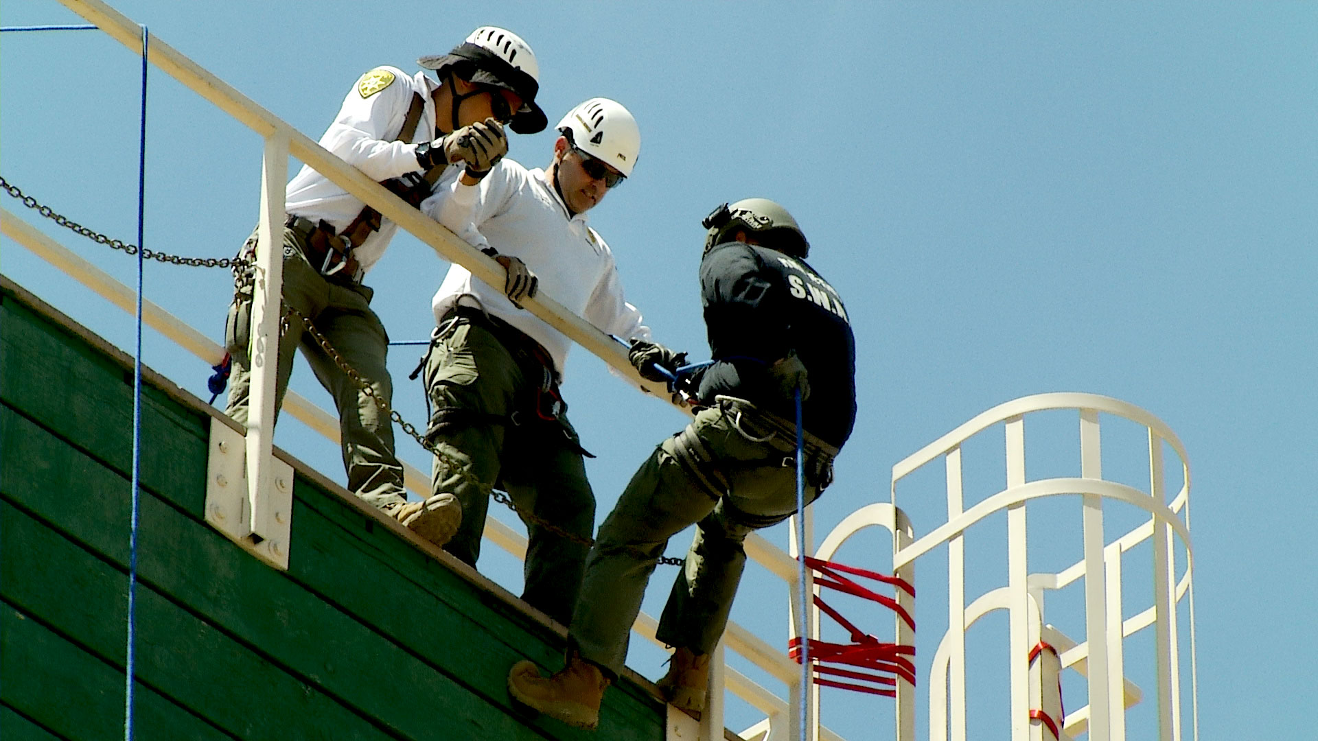 Members of Pima County Sheriff's Department Search and Rescue Unit help a member of the department's SWAT team repel down a wall in a training exercise at the Pima Regional Training Center on June 26, 2019.  