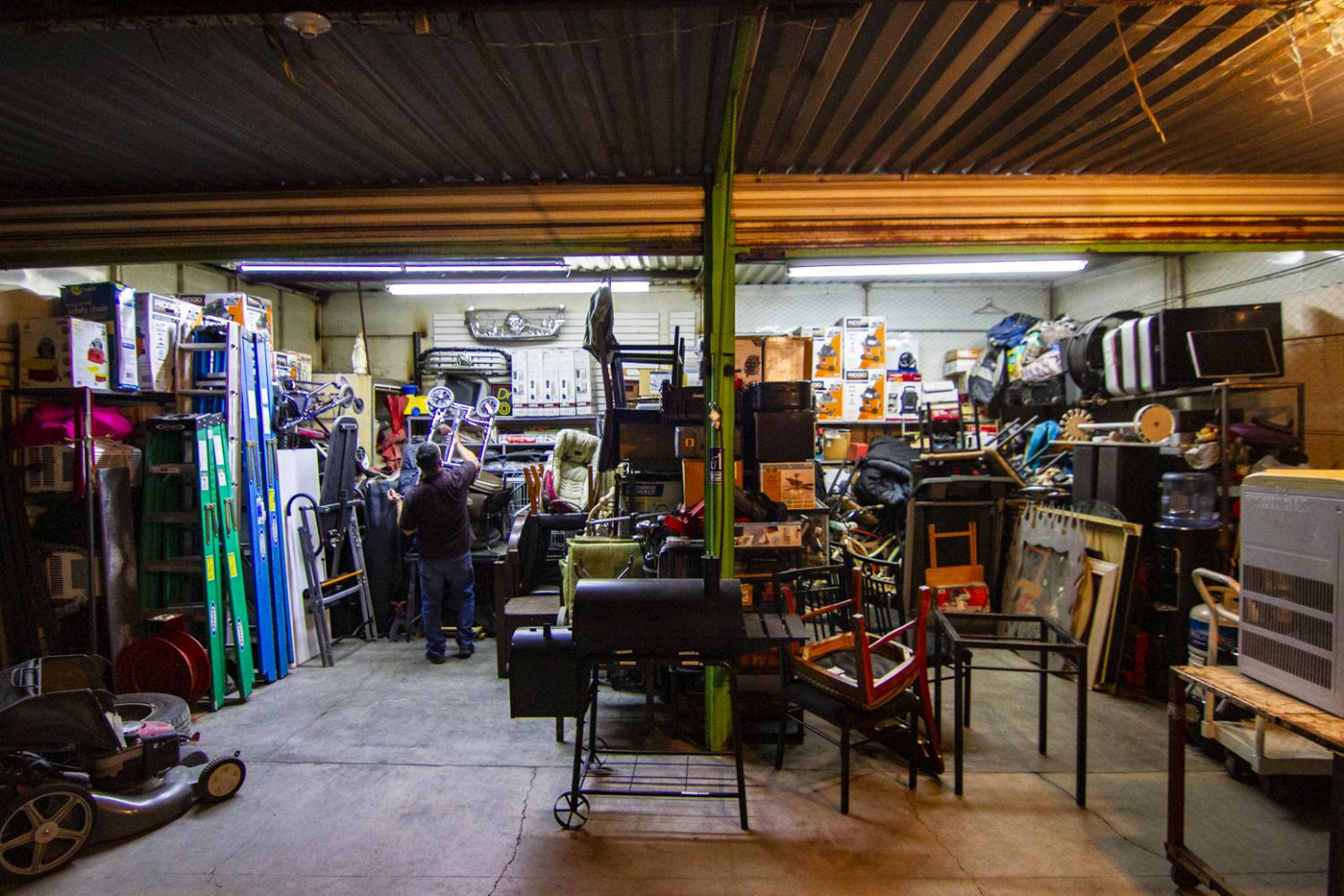 Benito Encinas fills up one of his Tianguis stands with a fresh batch of used Arizona goods that he picked up at Phoenix-area yard sales.