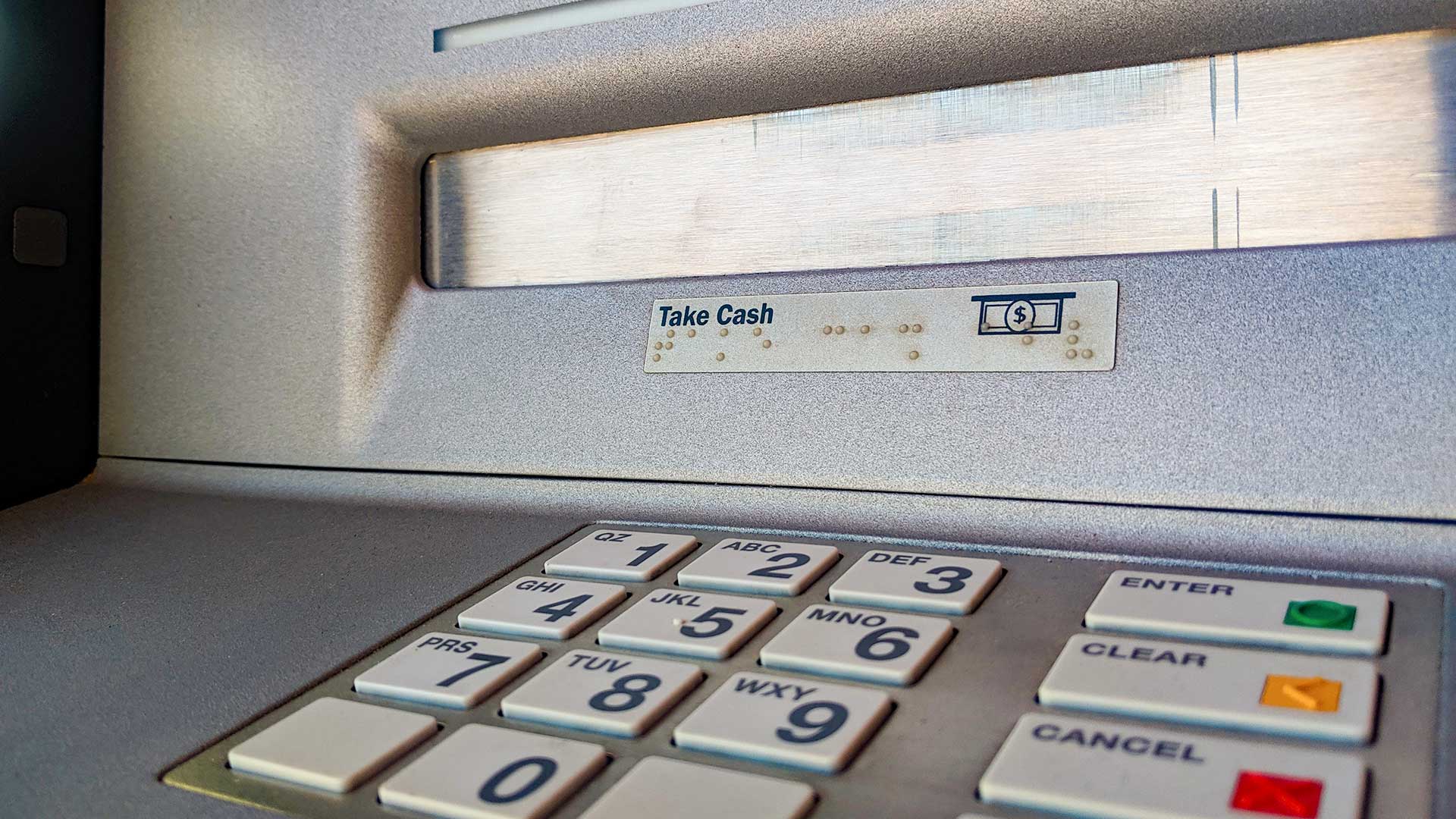 The number pad and cash dispenser at an ATM.