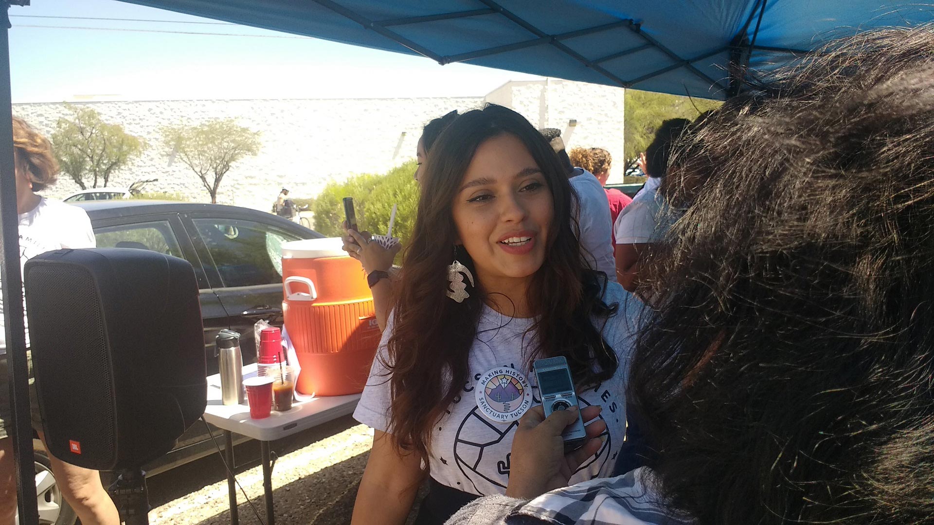 Zaira Livier, executive director of the People's Defense Initiative, speaks to a reporter after a news conference on July 3, 2019, at which the group announced it had collected more than 18,000 signatures for its "sanctuary city" initiative.