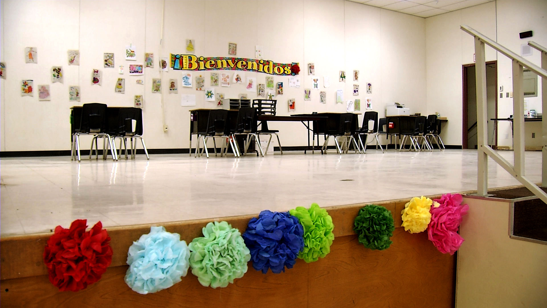 A stage inside the former Ann Ott Elementary School in Phoenix now serves as the intake area for staff and volunteers with the International Rescue Committee who process asylum-seeking families staying at the former school-turned shelter. 