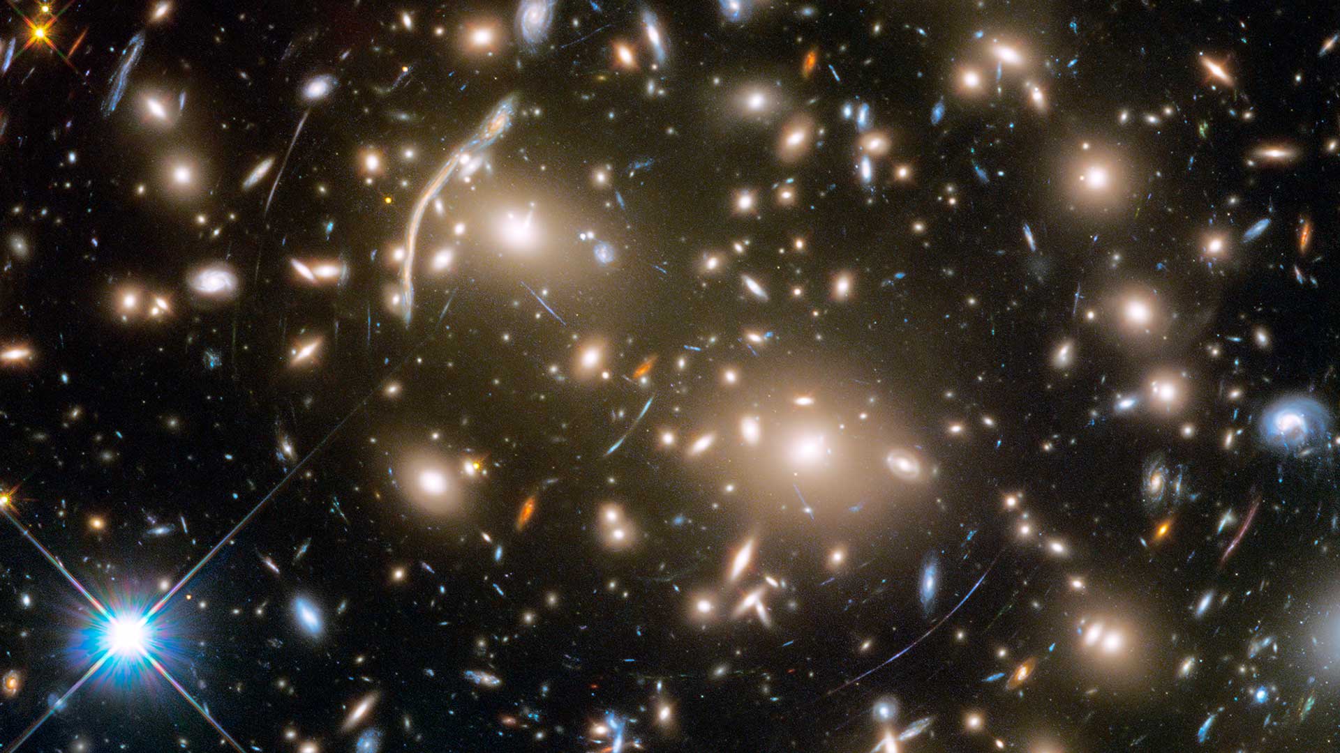 The Hubble Space Telescope took this image of Abell 370, a galaxy cluster 4 billion light-years from Earth. Several hundred galaxies are tied together by gravity. The arcs of blue light are distorted images of galaxies far behind the cluster.
