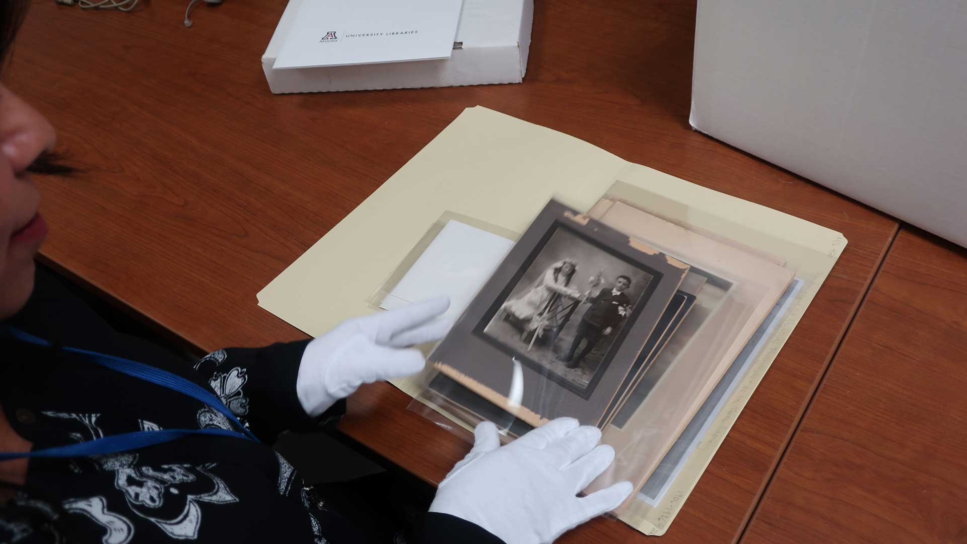 Verónica Reyes-Escudero examines photos from the de la Torre family collection at UA Special Collections.