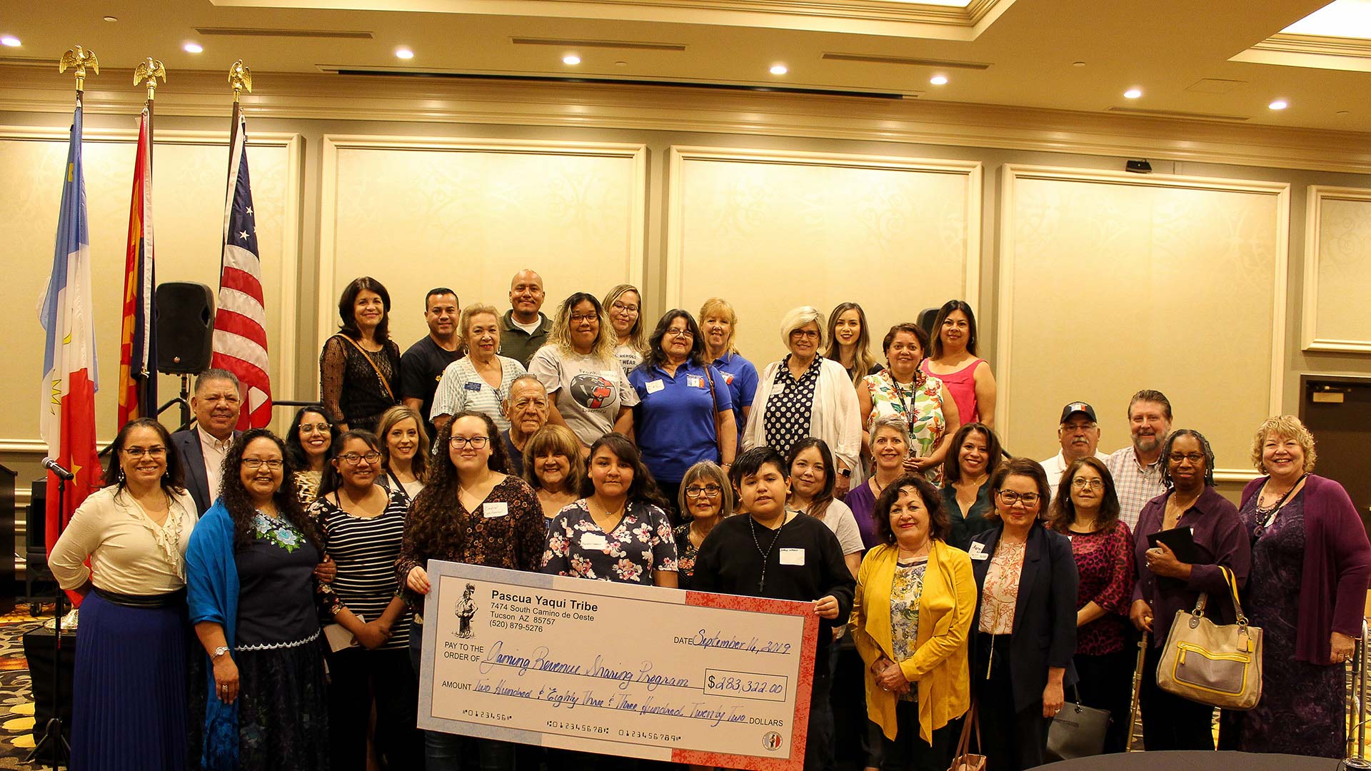 Tribal officials and representatives from the 14 organizations that received a grant through the Pascua Yaqui Tribe's gaming contributions pose September 16, 2019, with a check for the total amount donated to the organizations.