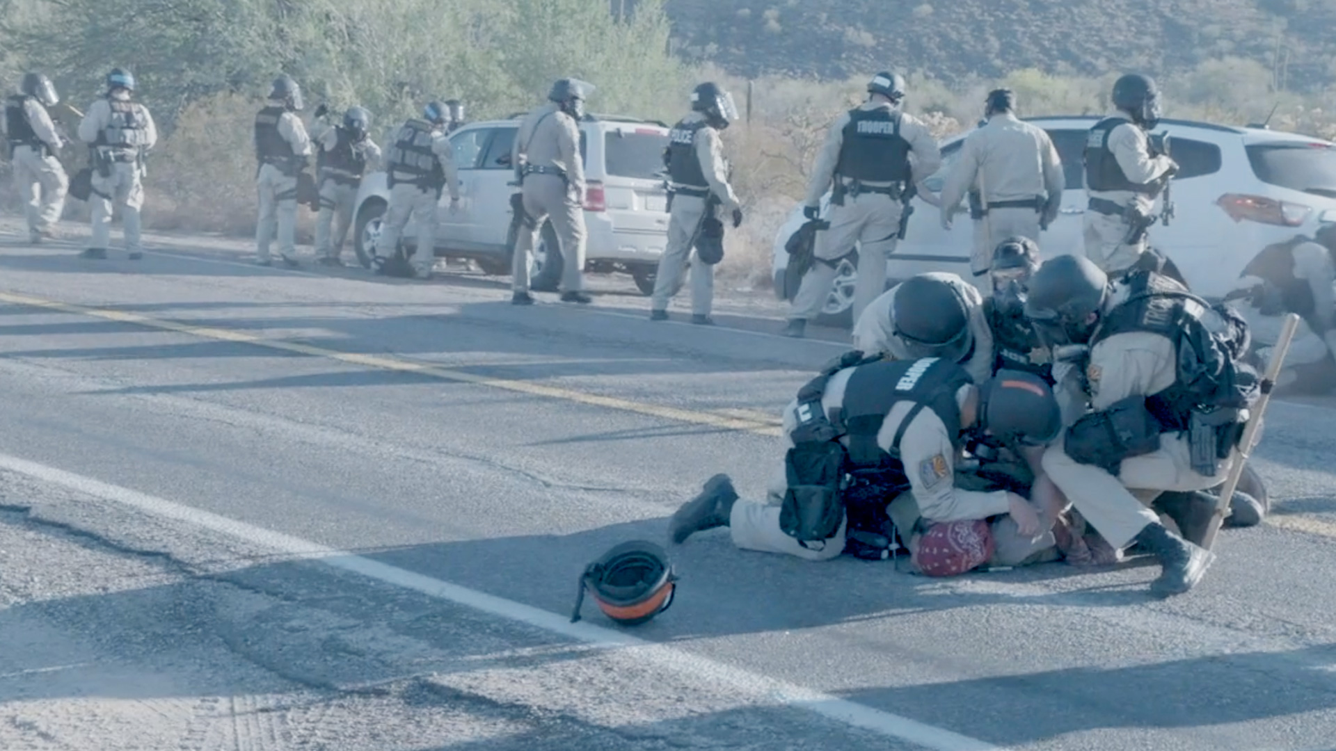 Arizona Department of Safety officers surround and handcuff an Indigenous demonstrator during an O'odham-led blockade at a Border Patrol checkpoint on Highway 85 on October 12, 2020.