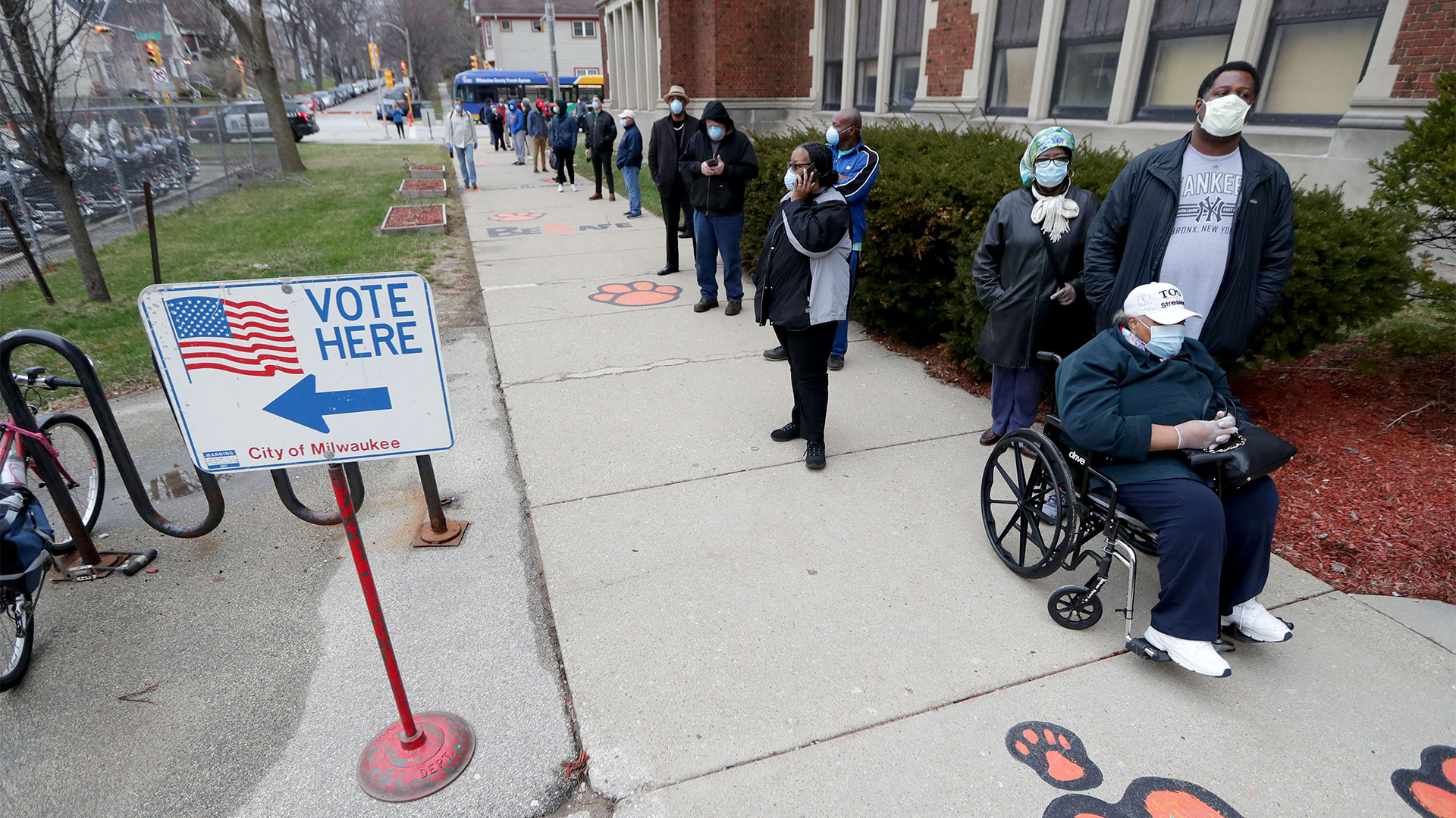 Residents of Milwaukee, Wisconsin wait in line to vote in the presidential primary election while wearing masks and practicing social distancing. April 7, 2020.