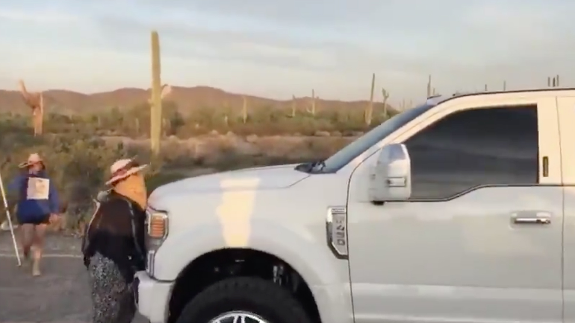 An O'odham demonstrator stands in front of a pickup truck trying to break through a highway blockade the morning of Oct. 5, 2020.