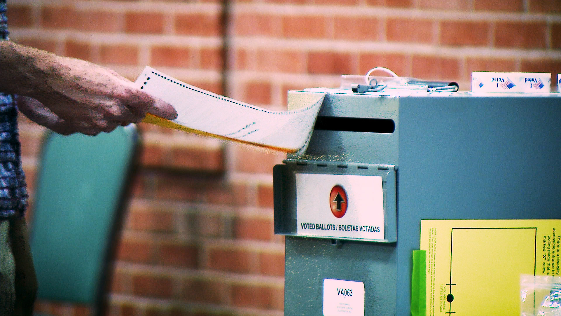 A voter turns in his ballot at a polling site set up at Tucson's Temple Emanu-El on the day of Arizona's primary election, Aug. 4, 2020.