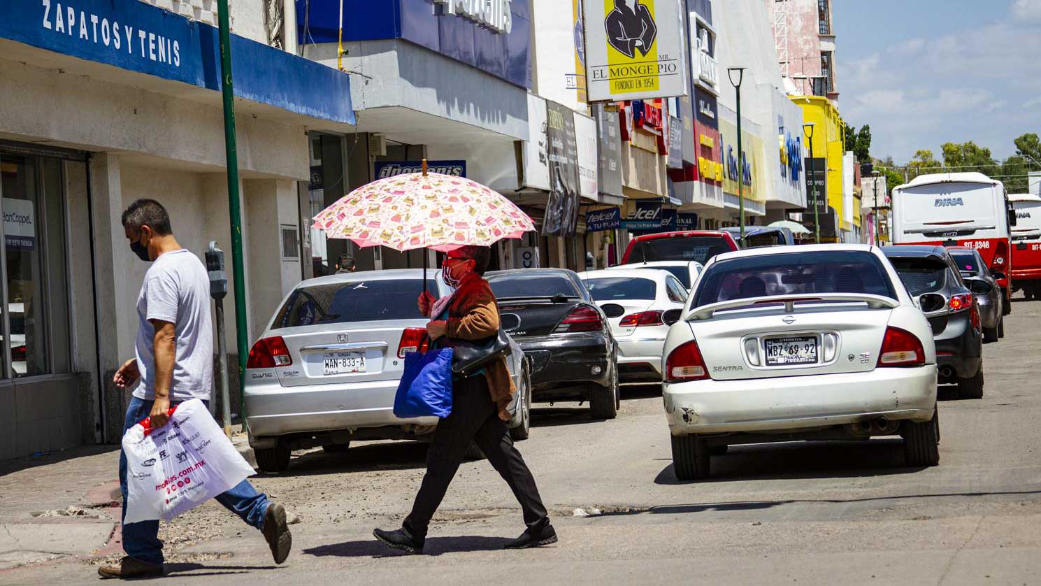 Pedestrians in masks cross the street in Hermosillo, Sonora.