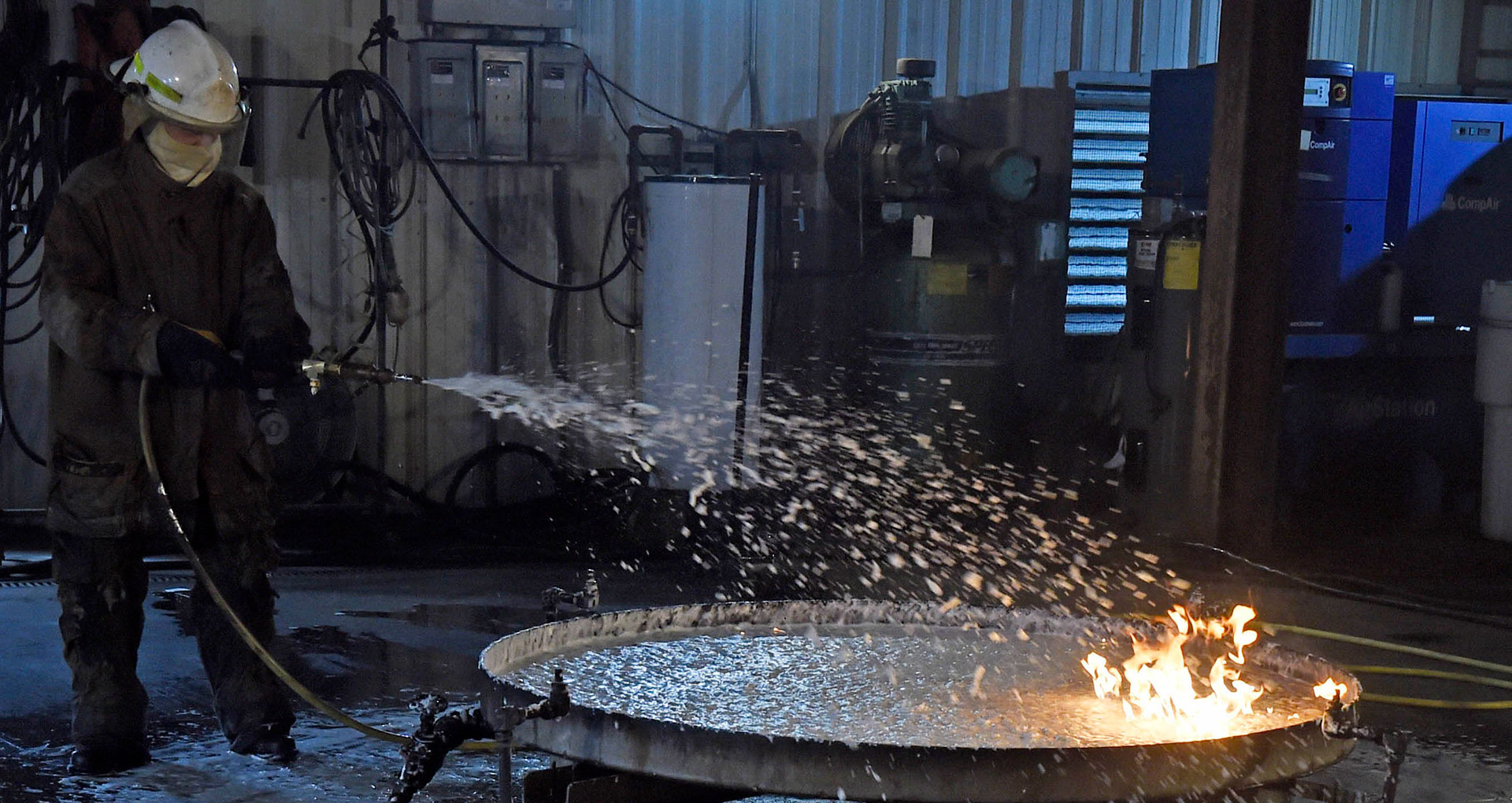 John Farley, director of fire test operations at the Naval Research Laboratory, tests the effectiveness of aqueous film-forming foam by spraying it on a gasoline fire. The test took place at the laboratory in Chesapeake Beach, Md. Oct. 25, 2019.
