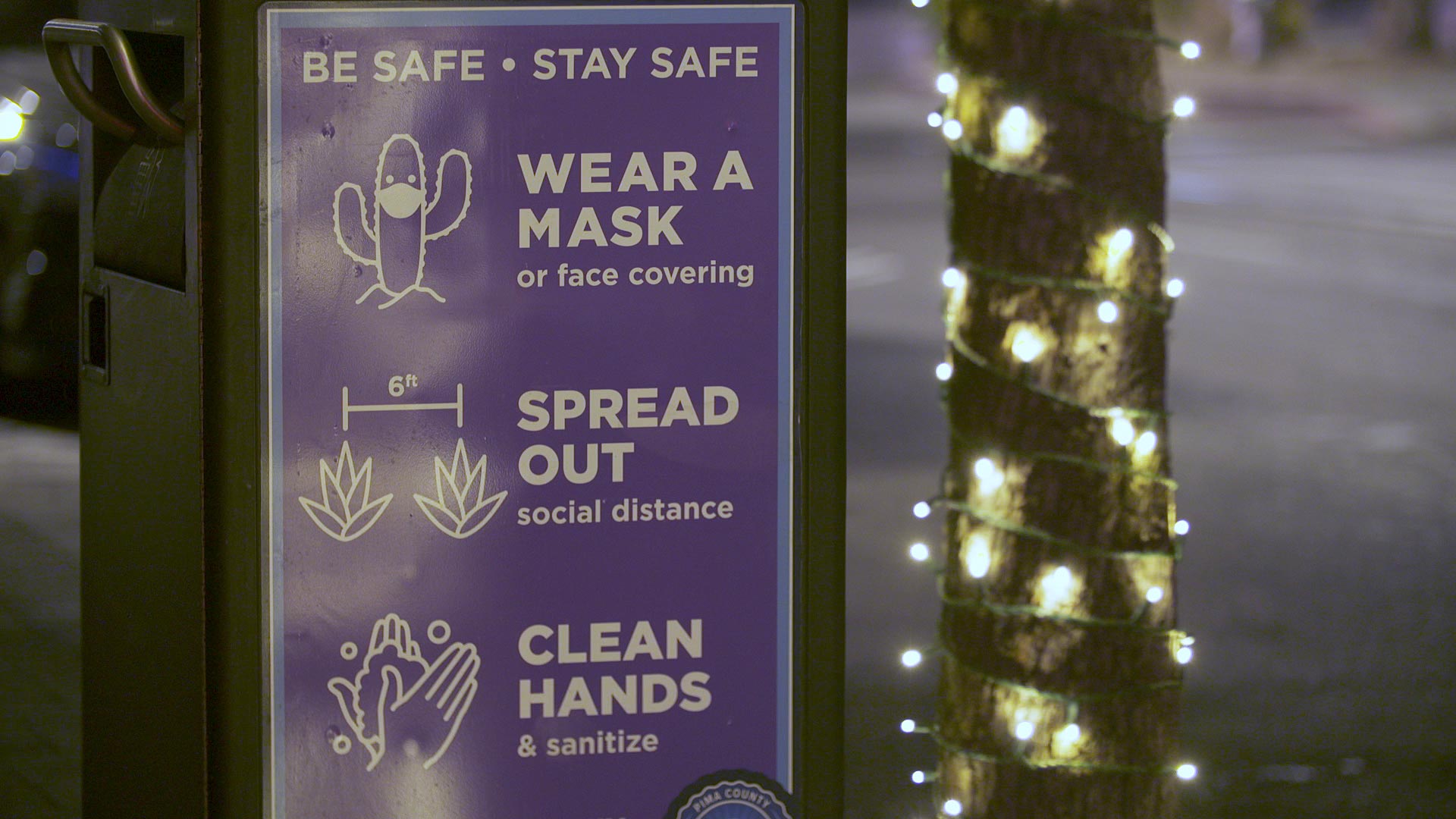 With holiday decorations up in downtown Tucson, a sign reminds the public to follow health guidelines to deter the spread of COVID-19. Nov. 23, 2020. 