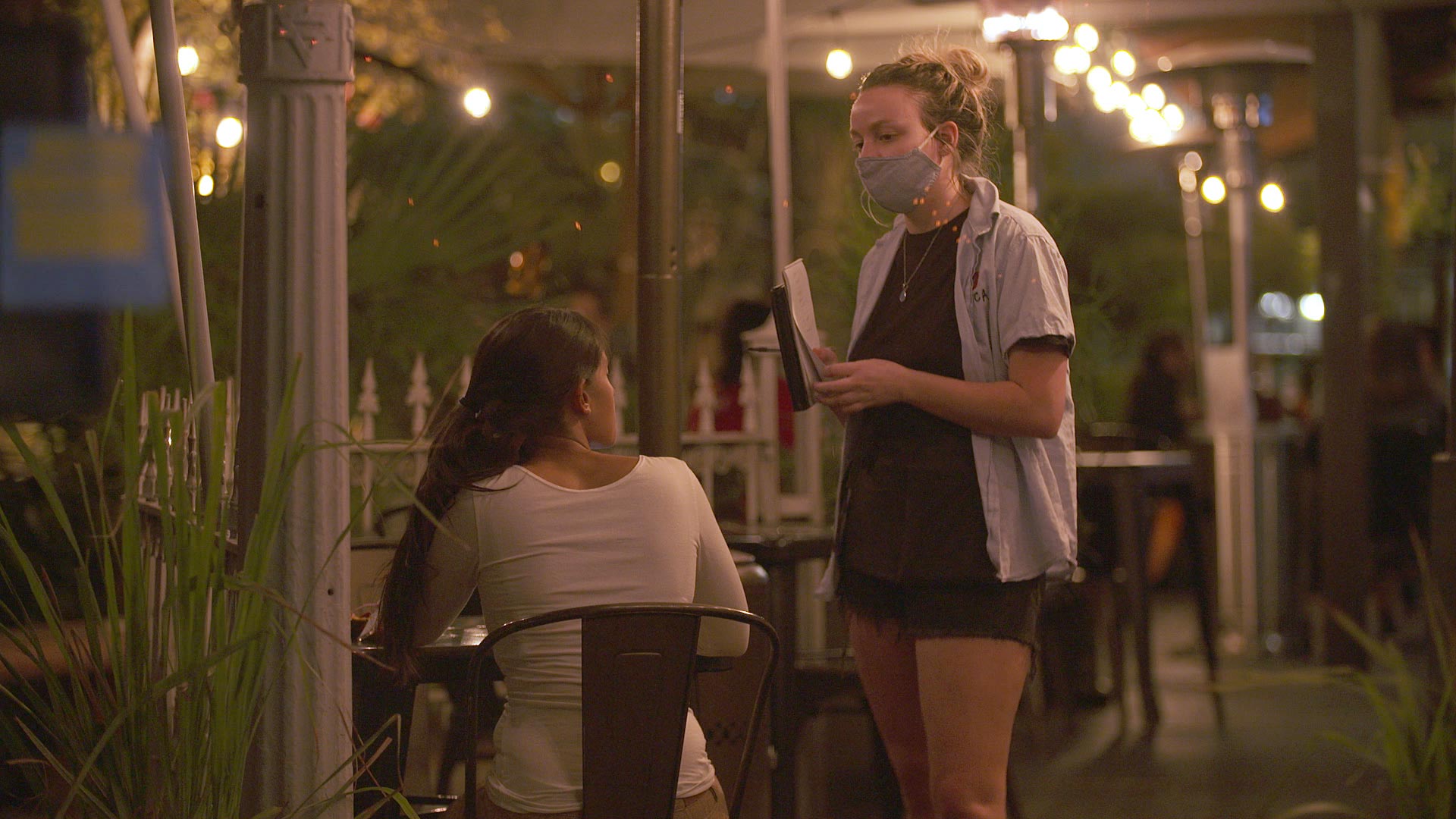 A server at Boca Taco on 4th Avenue speaks to a customer at a table outdoors on Nov. 23, 2020. 