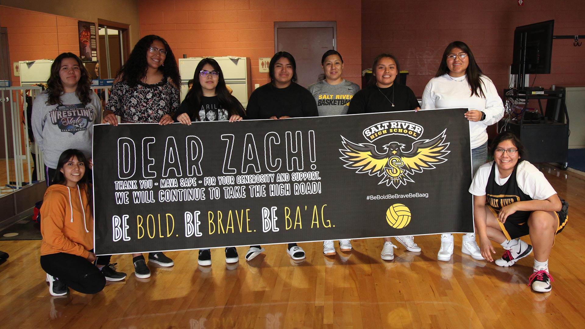 Salt River High School volleyball girls display a sign thanking Zach Galifianakis for donating to their team. They say his donation is a response to their game on Oct. 22, 2020, in which they say spectators called them "savages" and made offensive gestures.